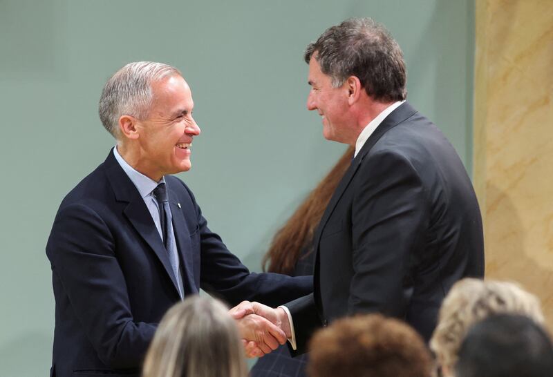 Canada's Prime Minister Mark Carney shakes hands with Dominic LeBlanc, after he is sworn in as President of the King's Privy Council for Canada and Minister responsible for Canada-U.S. Trade, Intergovernmental Affairs and One Canadian Economy, at a cabinet shuffle at Rideau Hall in Ottawa, Ontario, Canada, May 13, 2025.  REUTERS/Patrick Doyle/Pool