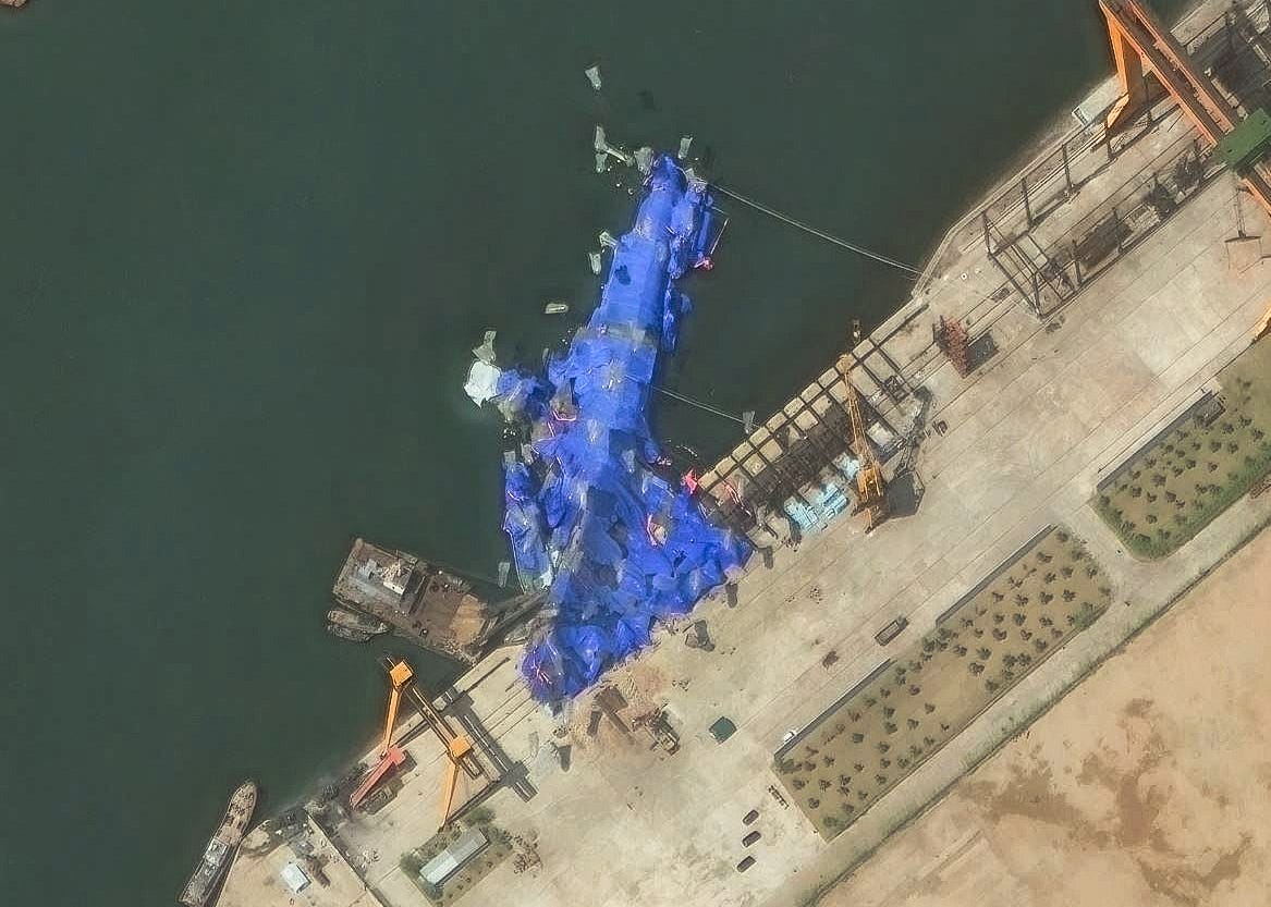 Satellite imagery shows a North Korean warship partially covered with blue tarps after a failed launch.
