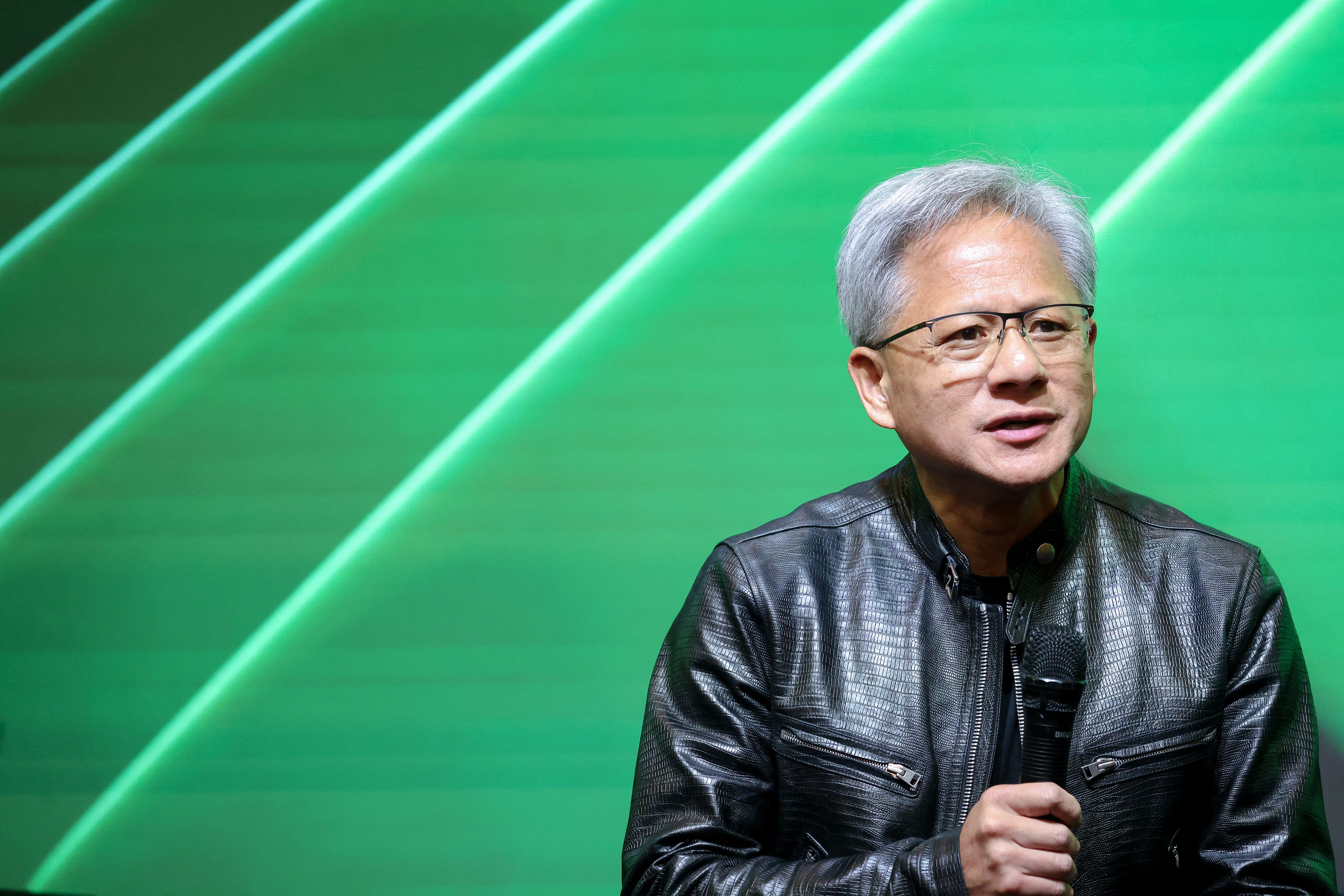 Jensen Huang holding a microphone.