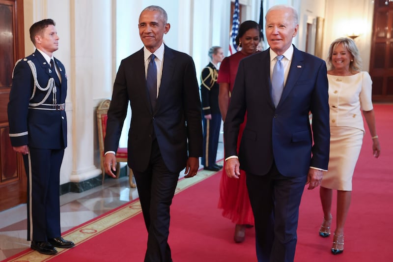 Barack Obama and Joe Biden walk down the hall in the White House in 2022.