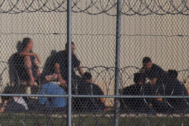 Migrants facing deportation from the U.S. are pictured behind a fence at the Bluebonnet Detention Facility, where a group of Venezuelans at the center of a Supreme Court case are being held, in Anson, Texas, on April 22, 2025.