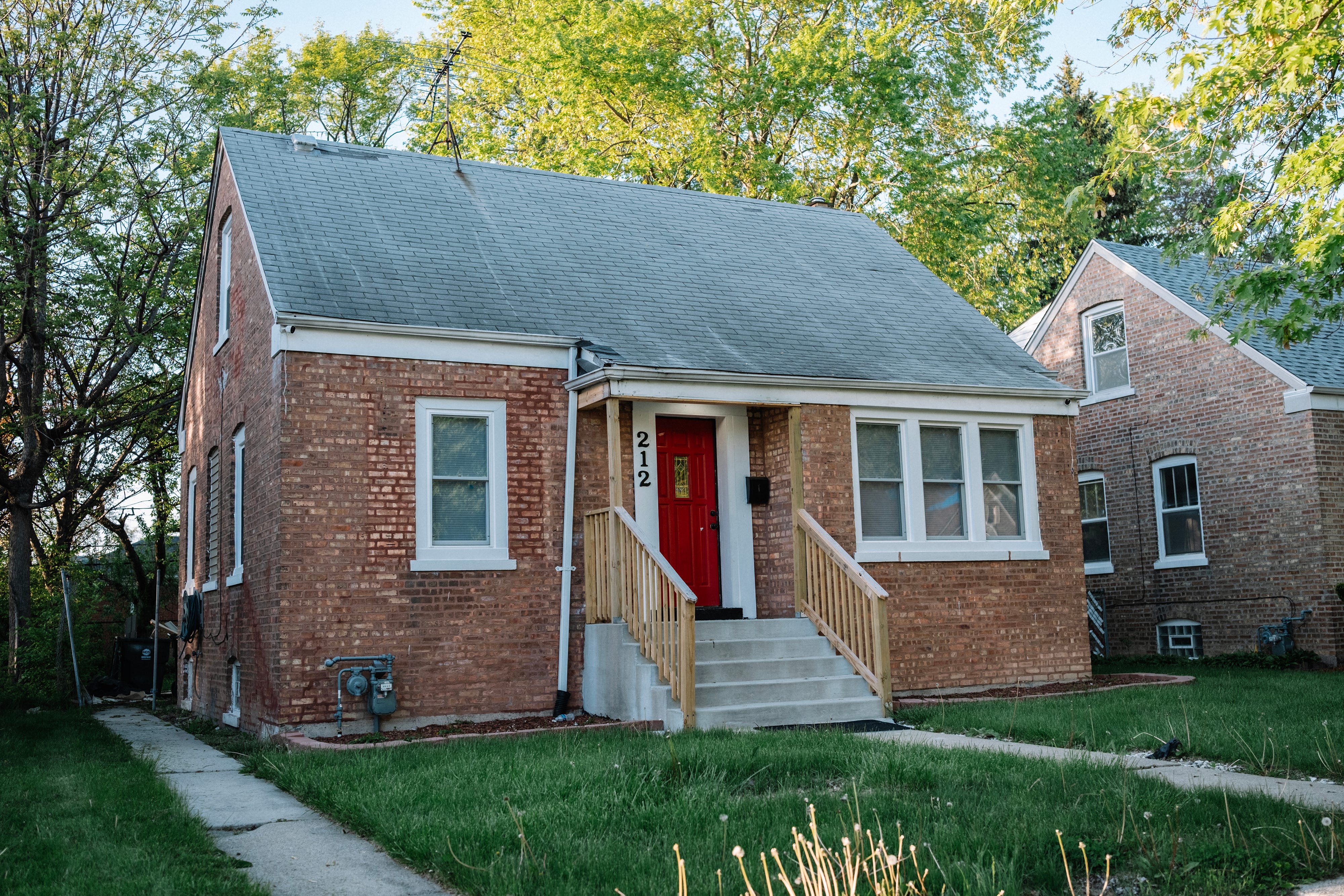 Small brick home with grass in front.