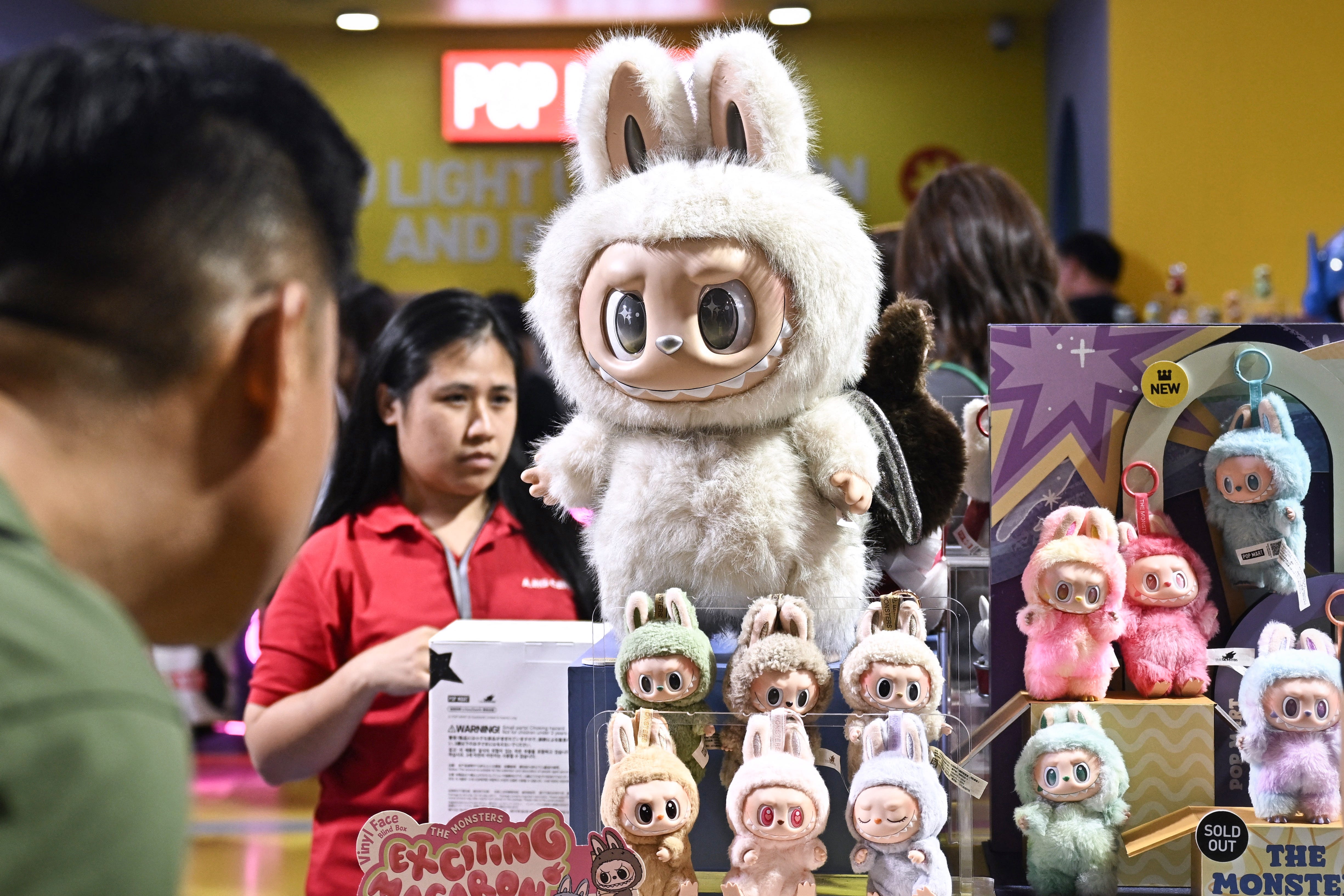 People look at collectable designer art toy Labubu at a Pop Mart pop-up store in Siam Center shopping mall in Bangkok.
