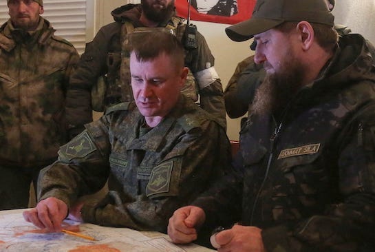 Andrei Mordvichev sits at a table with maps on with various Russian military figures and Chechen warlord Ramzan Kadyrov
