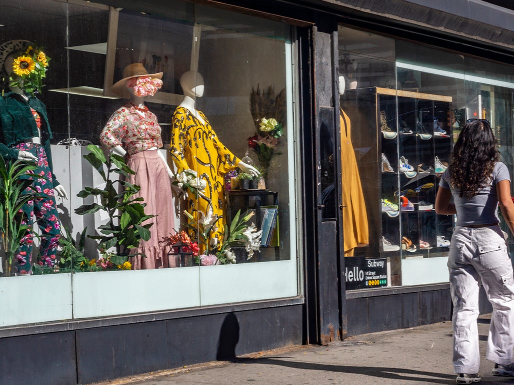 People walking past thrift store.