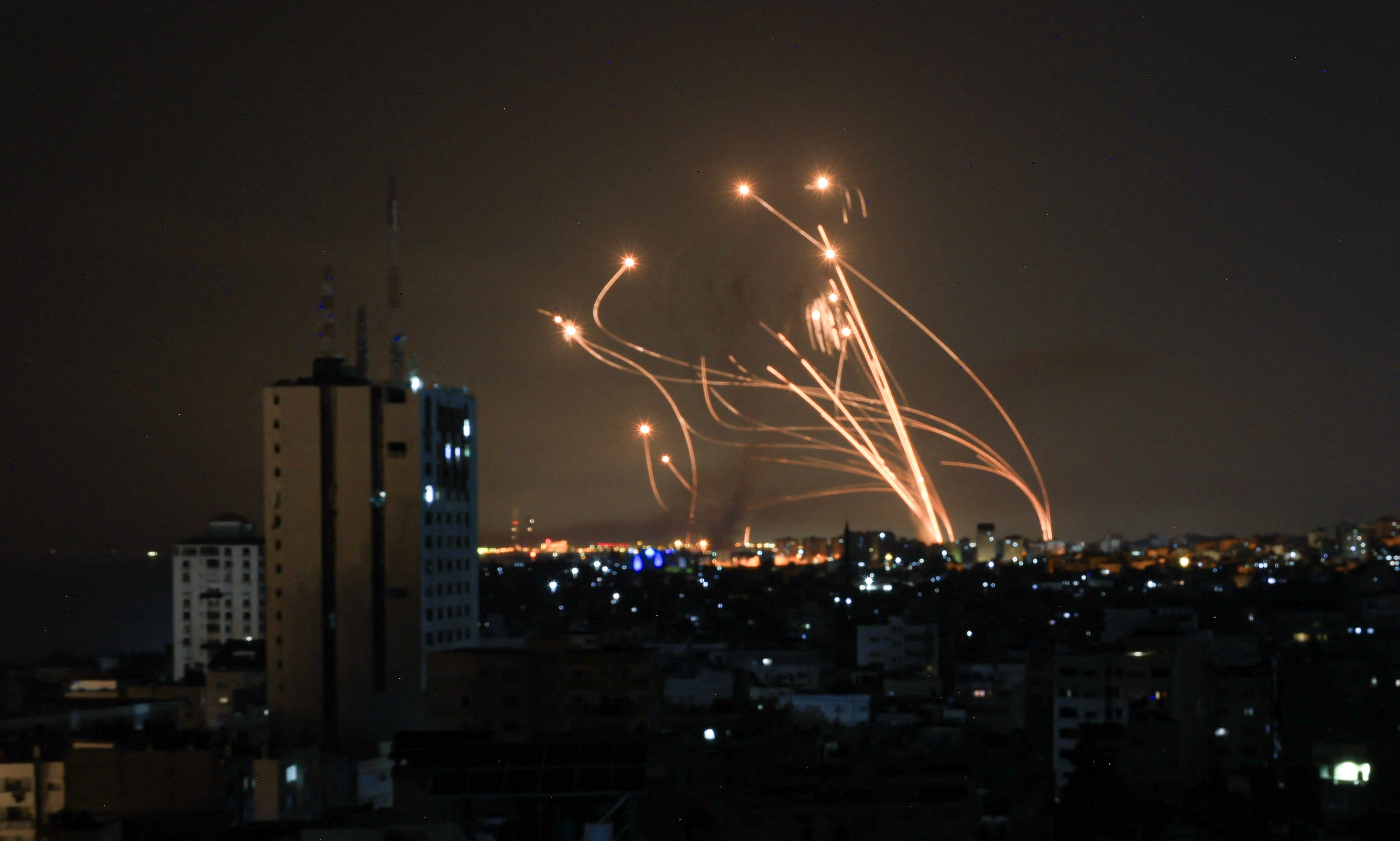 A photo of rockets intercepting each other in the night sky.