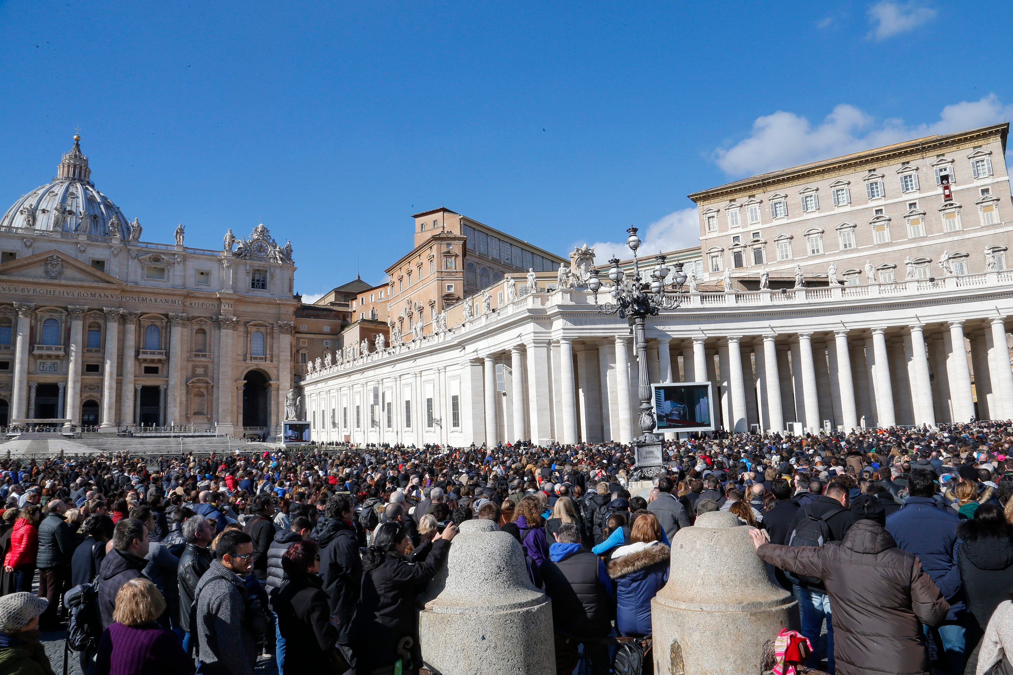 The exterior of the Apostolic Palace in Saint Peter's Square at the Vatican with a large crowd in front