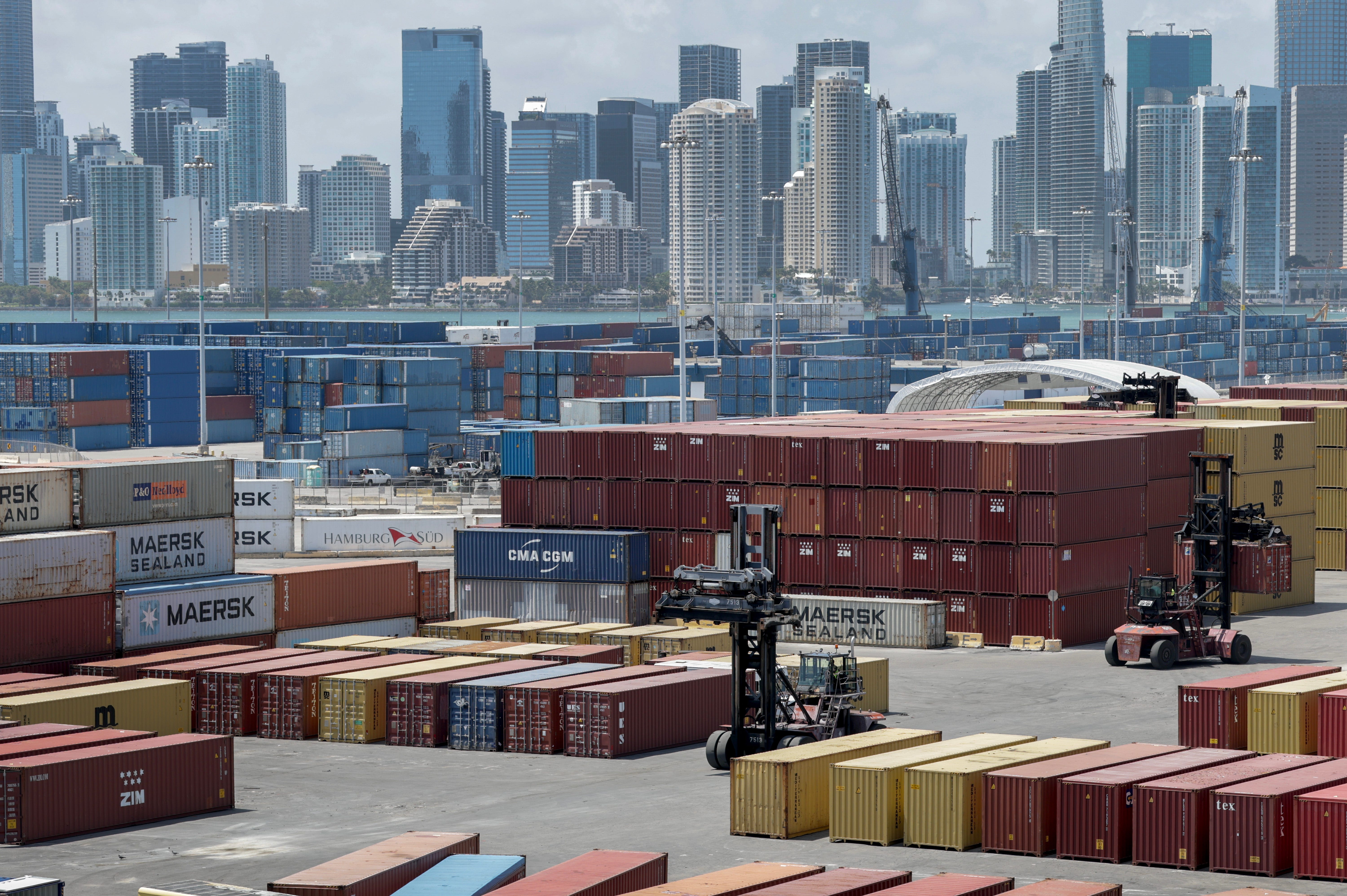 Forklifts move shipping containers at Port Miami on April 7, 2025 in Miami