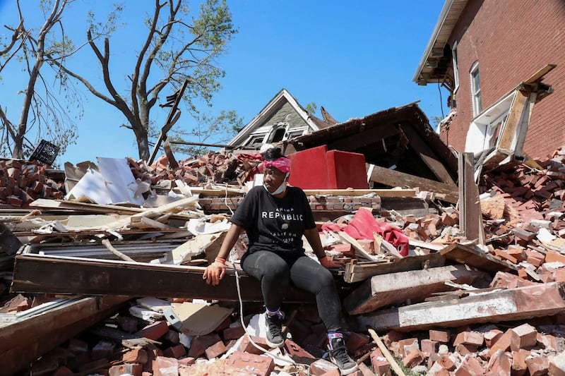 A woman sits on top of the wreckage of her home caused by the tornado in St. Louis
