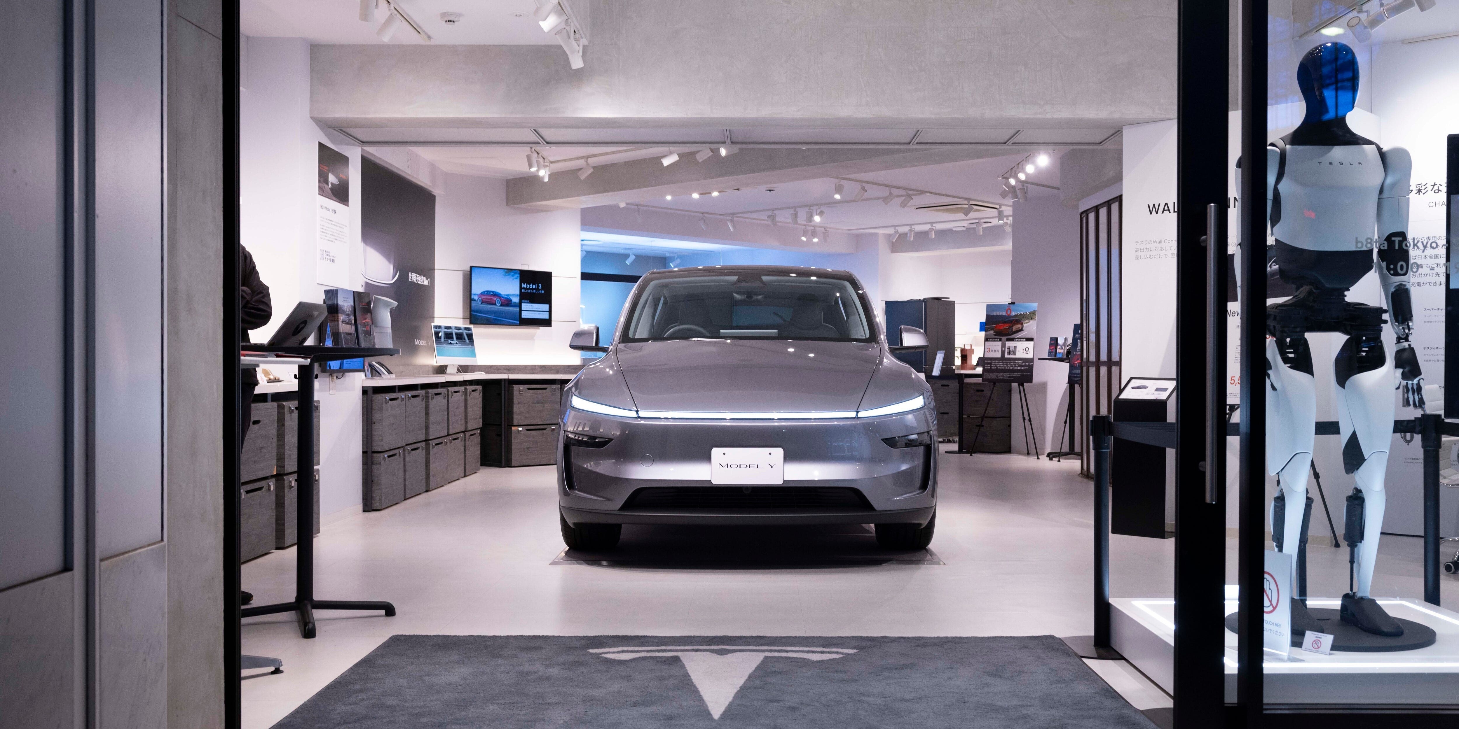 A gray Tesla Model Y inside a showroom.