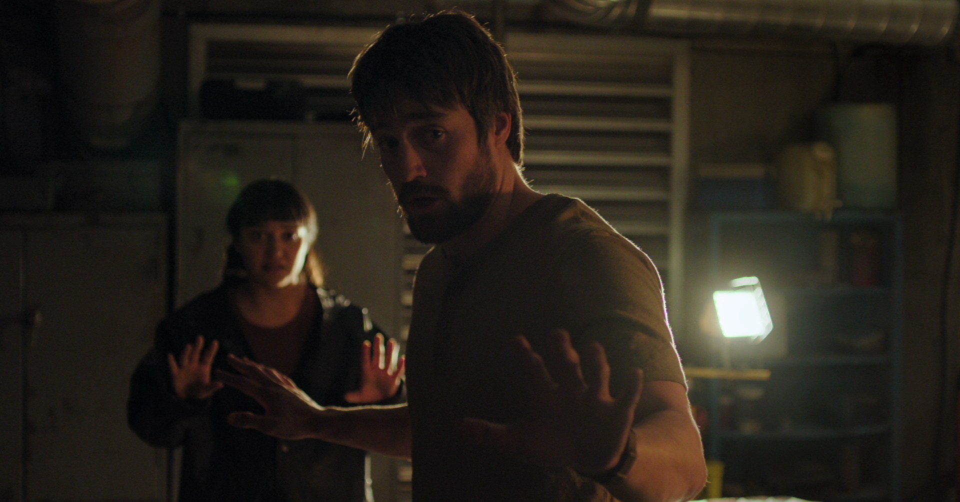 Owen and Mel from The Last of Us show hold their hands up as Ellie threatens them from off-camera.