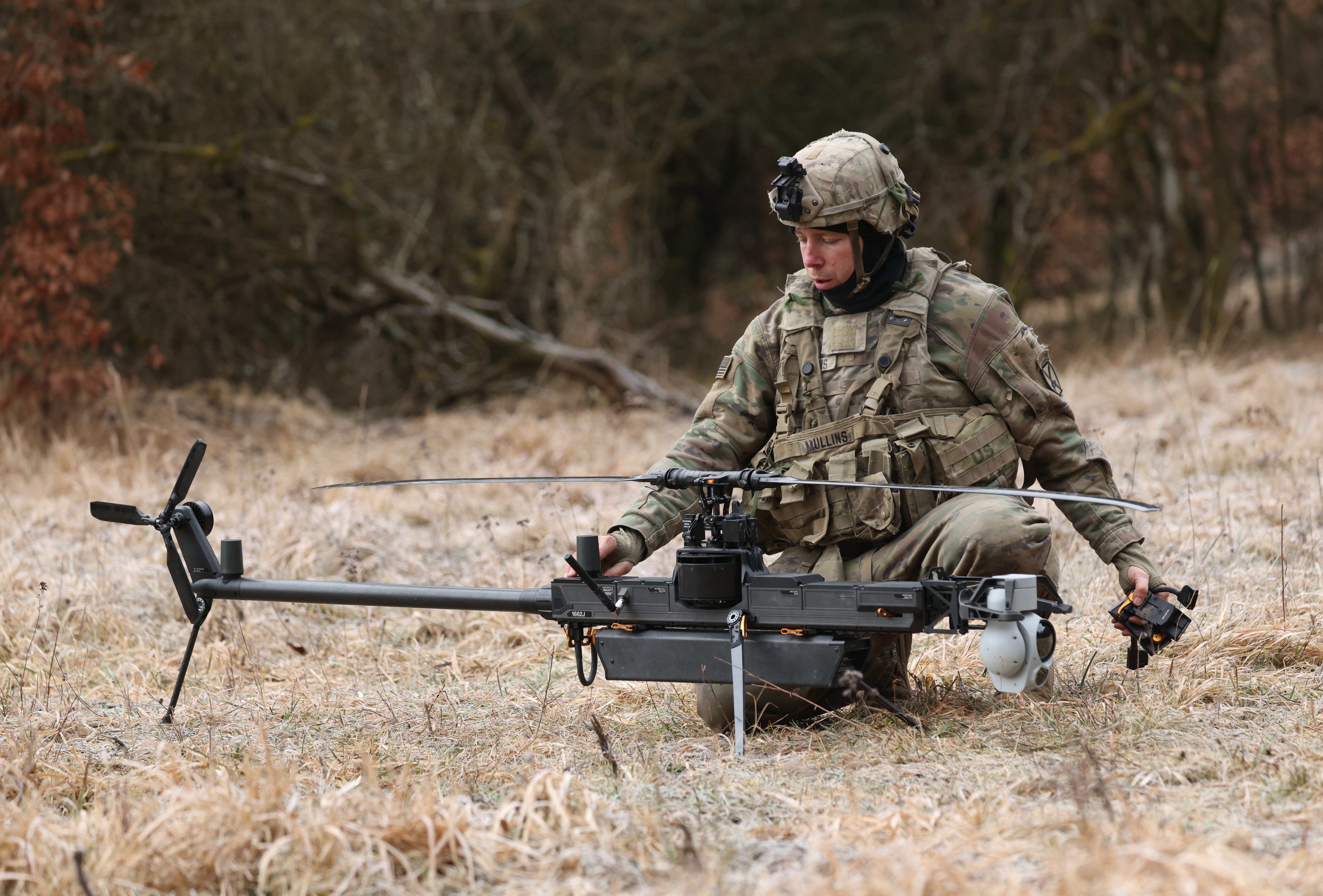 A soldier of a UAS (Unmanned Aircraft System) platoon of the U.S. Army 3rd Brigade, 10th Mountain Division, readies a Anduril Ghost-X helicopter surveillance drone.
