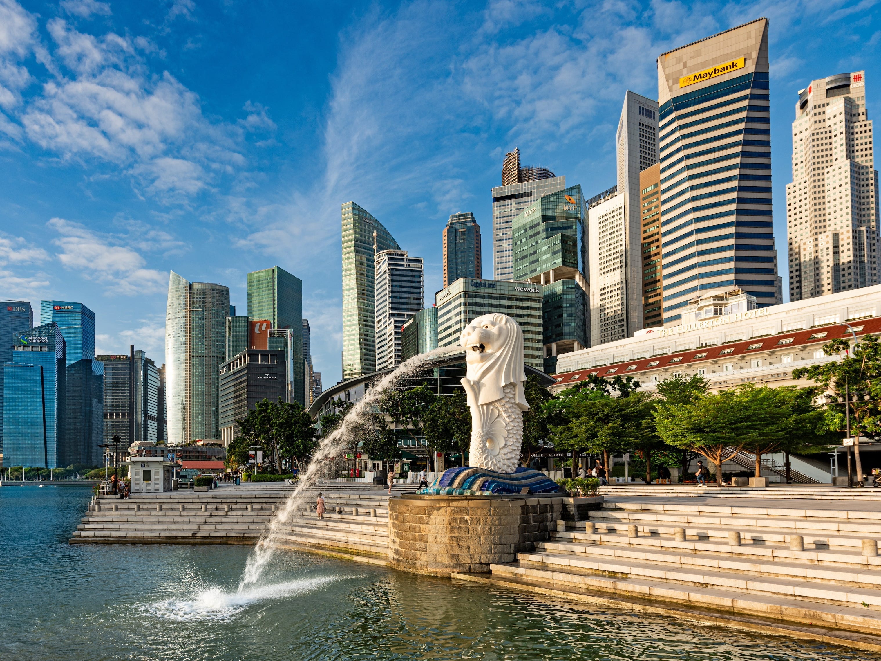 The Merlion statue at Merlion Park in Marina Bay in Singapore. Skyscrapers are in the background.