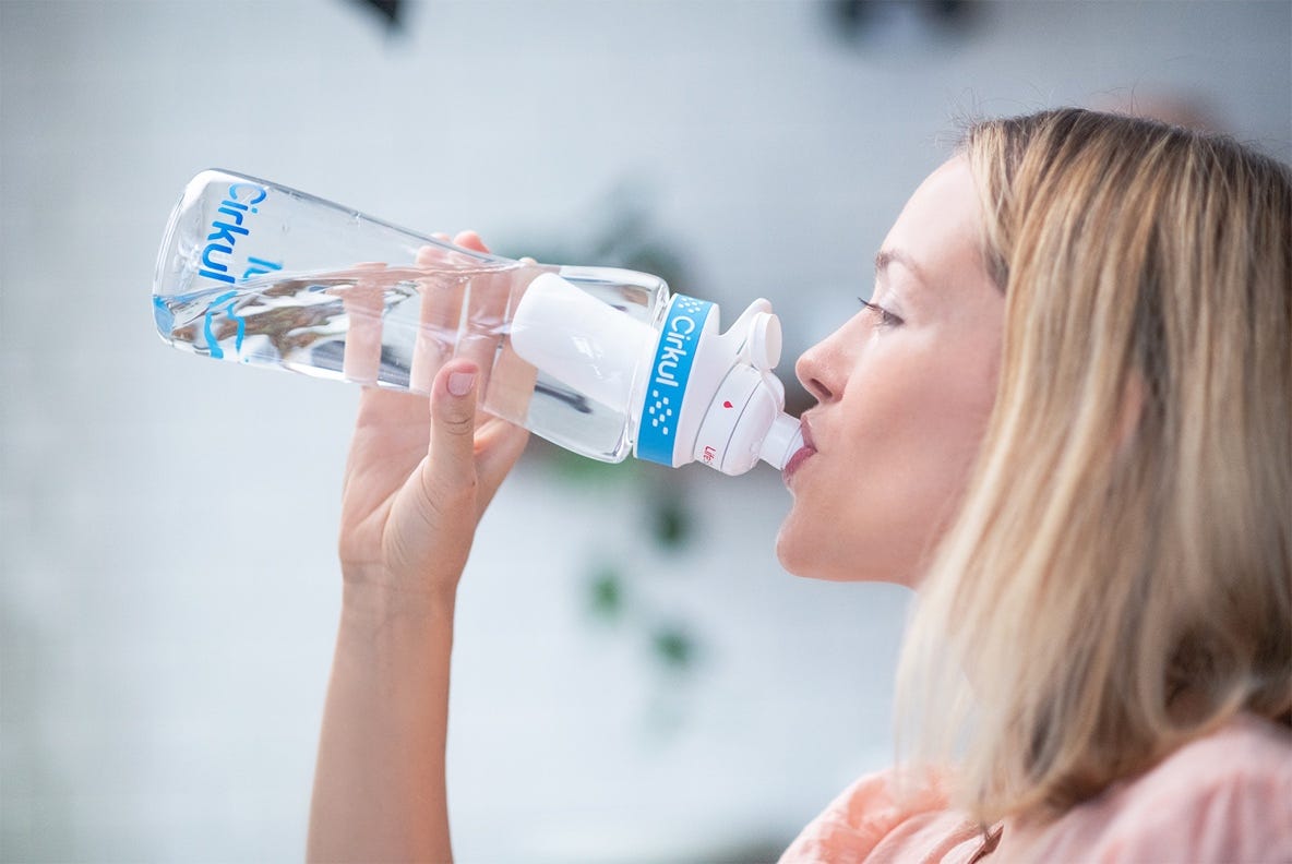 View from side of woman drinking water from Cirkul bottle