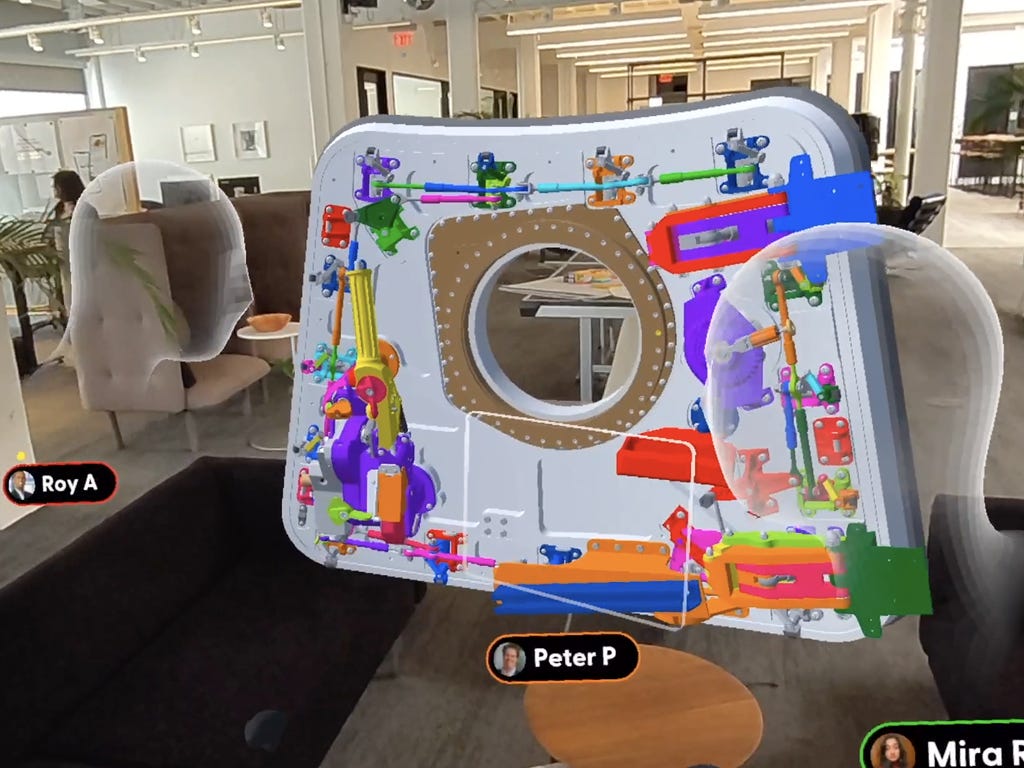 Three collaborators viewing a 3D model of a product in an office.