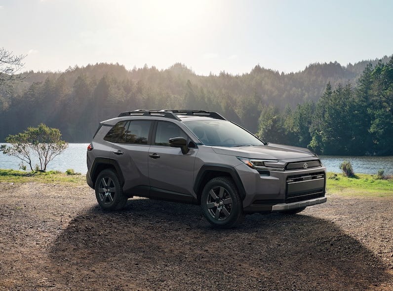 New Toyota RAV4 SUV pictured in front of a mountain lake with the sun shining