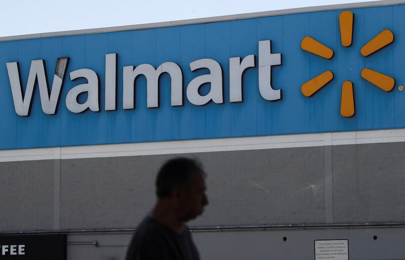 A man walks past the logo of Walmart on the facade at a store in Mexico City, Mexico