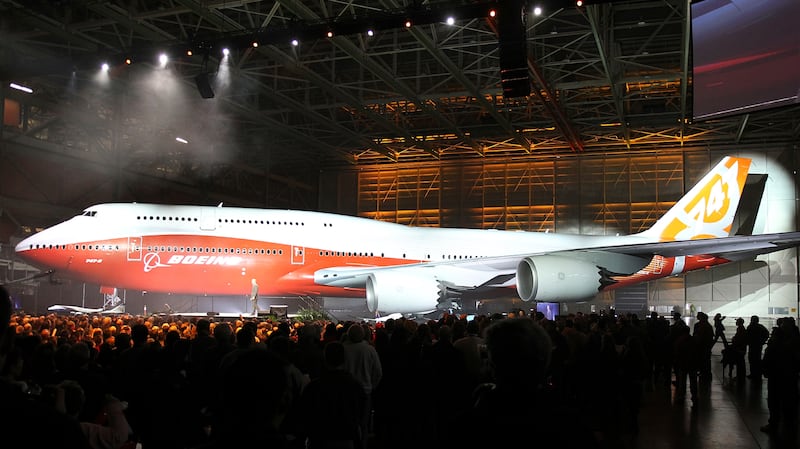 Boeing raises a curtain to unveil the 747-8 jumbo passenger jet to thousands of employees and guests at the company's Everett, Washington commercial airplane manufacturing facility, February 13, 2011. Boeing vice president and general manager of Boeing's Commercial Airplanes airplane program Pat Shanahan is pictured on the jumbo screen in the upper right as he officiated the ceremony. Boeing Co rolled out the new jumbo jet on Sunday, hoping to relive the glamor surrounding the birth of the 747 over 40 years ago and use it to boost slow sales. REUTERS/Anthony Bolante (UNITED STATES - Tags: TRANSPORT BUSINESS)