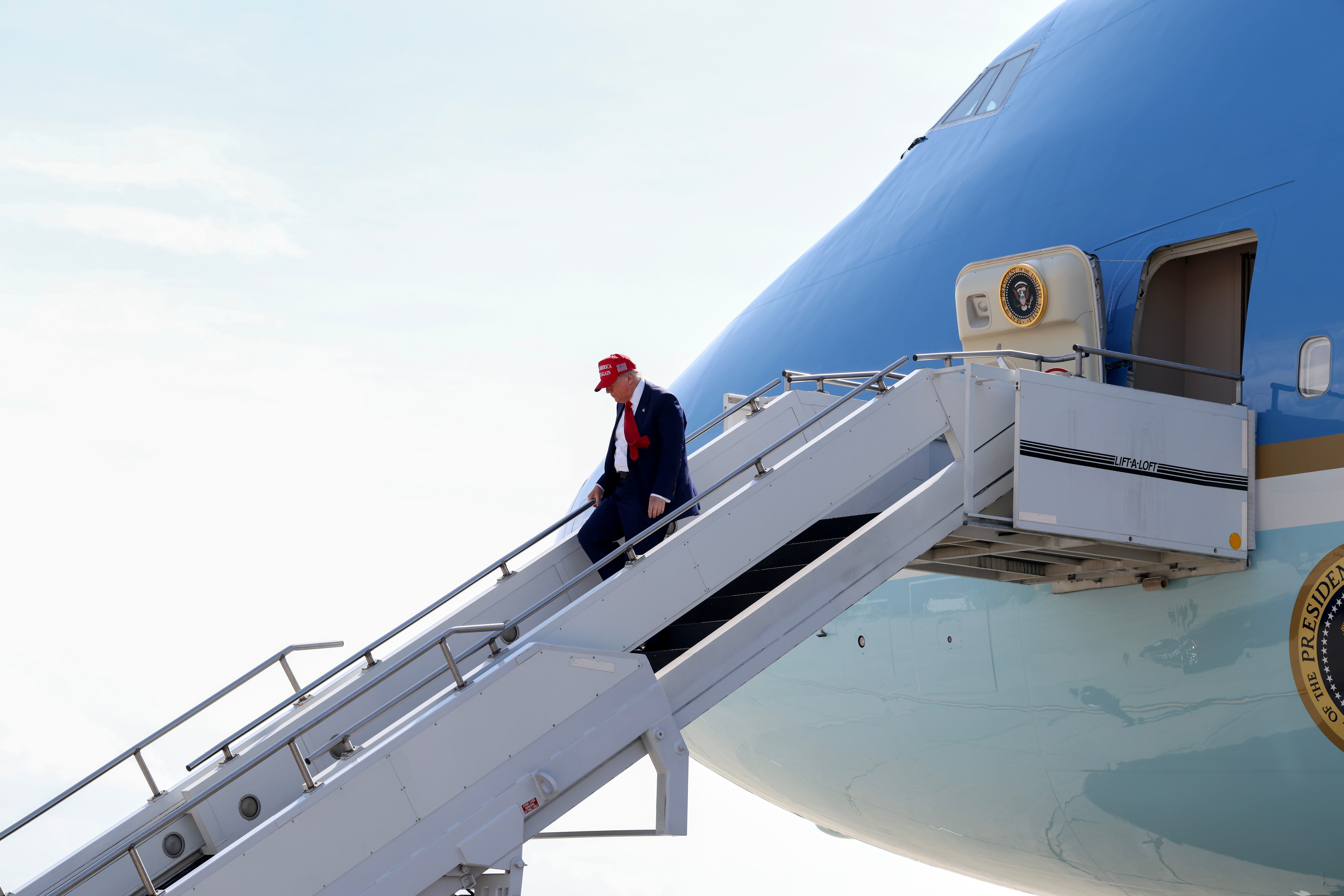 US President Donald Trump walks off Air Force One .