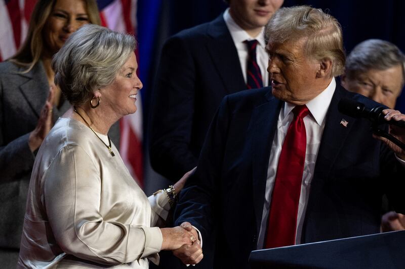 Republican presidential nominee and former U.S. President Donald Trump shakes hands with his senior advisor Susie Wiles as he speaks, following early results from the 2024 U.S. presidential election in Palm Beach County Convention Center, in West Palm Beach, Florida, U.S., November 6, 2024.