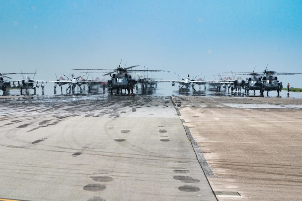 US Air Force and Navy fighter jets and military helicopters line up on the runway for an elephant walk on Kadena Air Base.