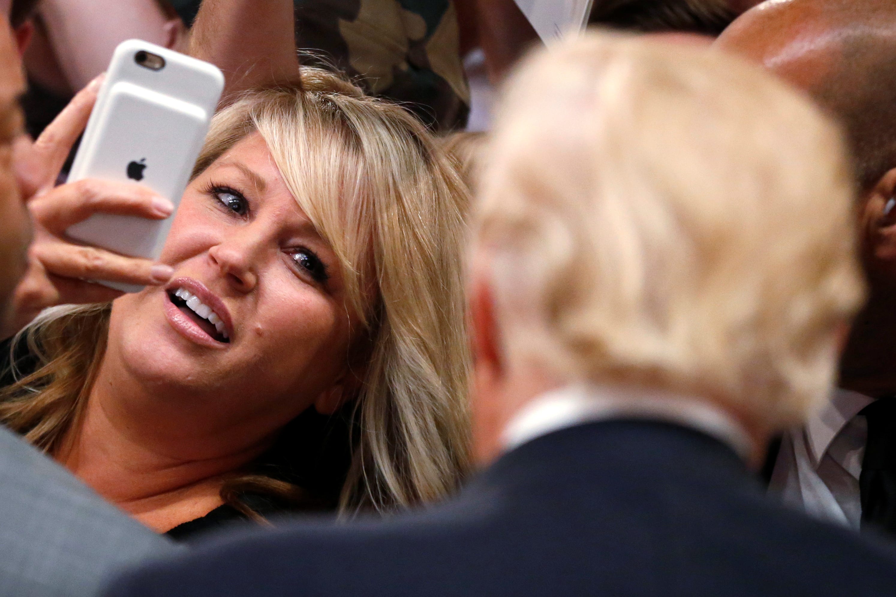 A woman points her iPhone toward Donald Trump at a campaign rally in California