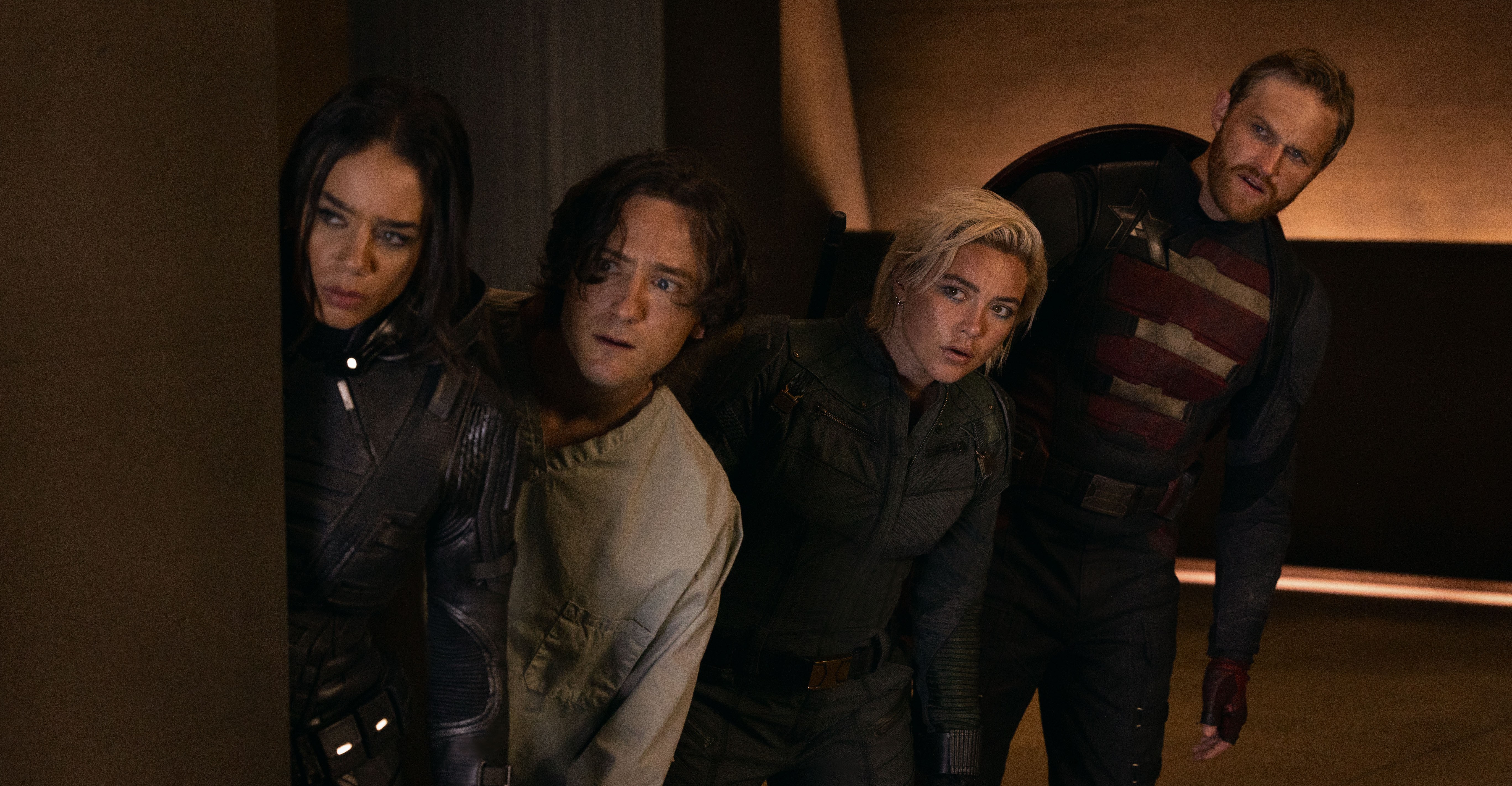 Hannah John-Kamen as Ghost, Lewis Pullman as Bob, Florence Pugh as Yelena, and Wyatt Russell as John Walker in Thunderbolts*, all leaning around a corner together while in their superhero costumes