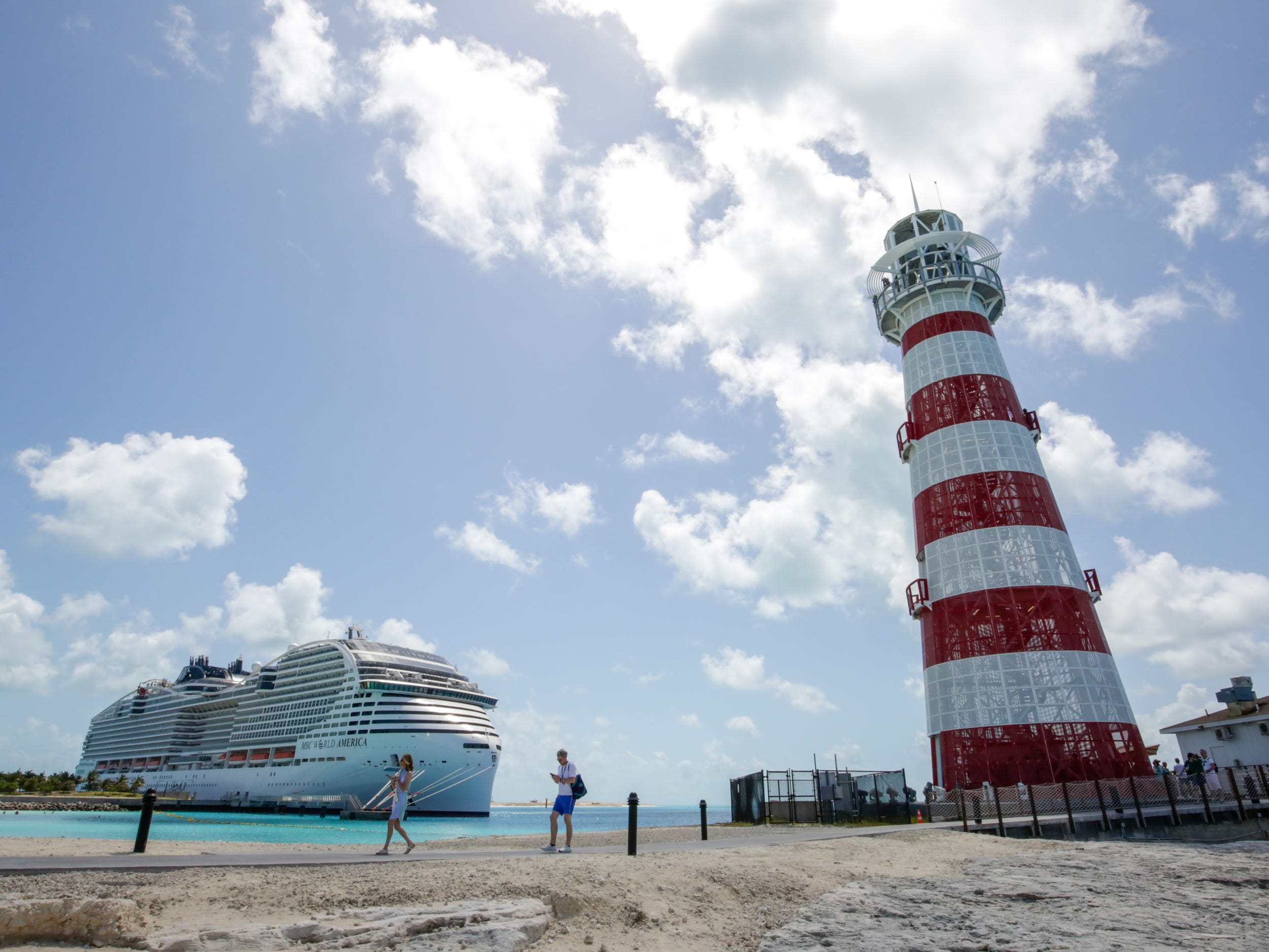 MSC World America docked next to the lighthouse of its private island, Ocean Cay
