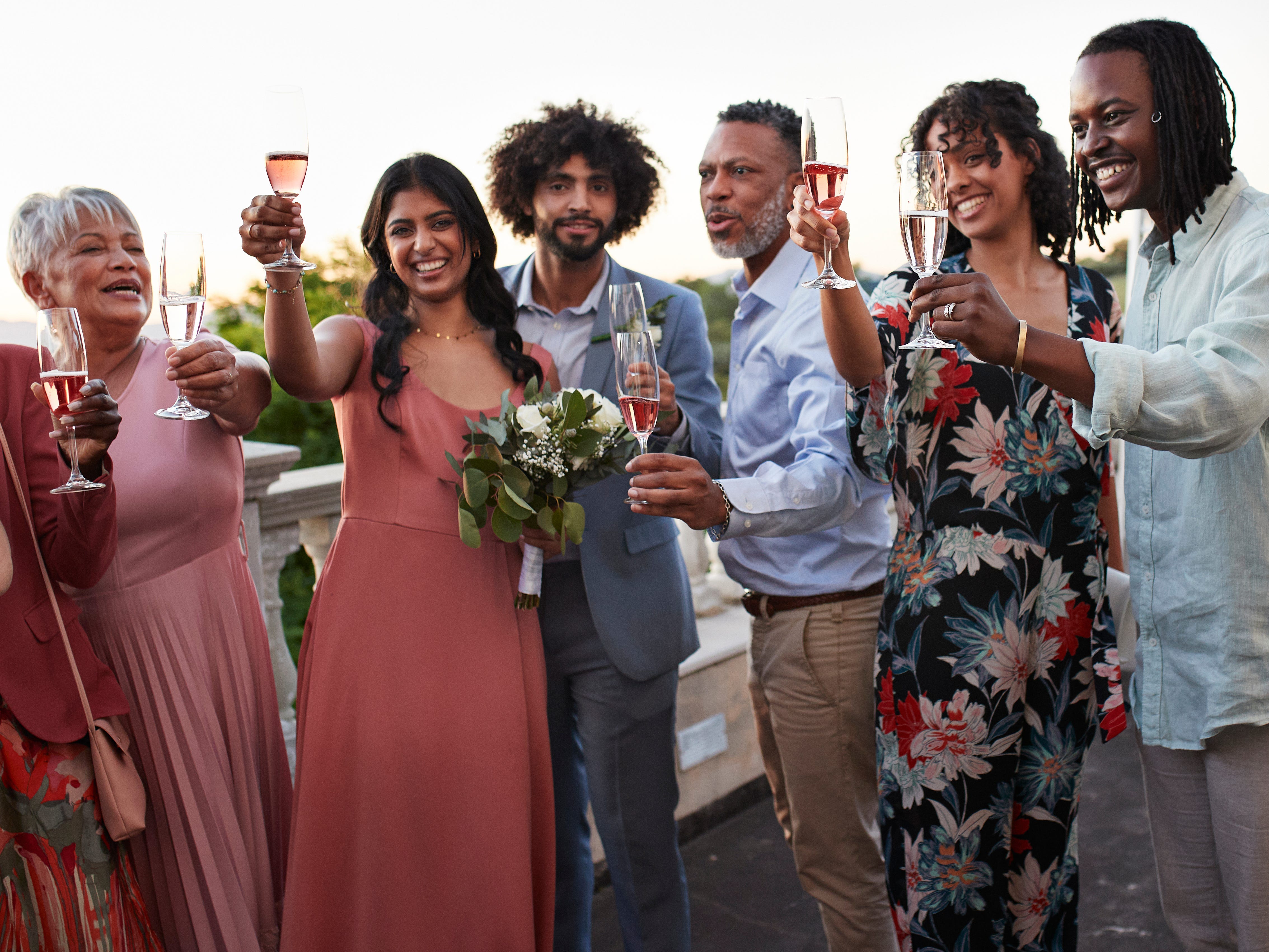 Wedding guests holding up glasses of wine and Champagne.