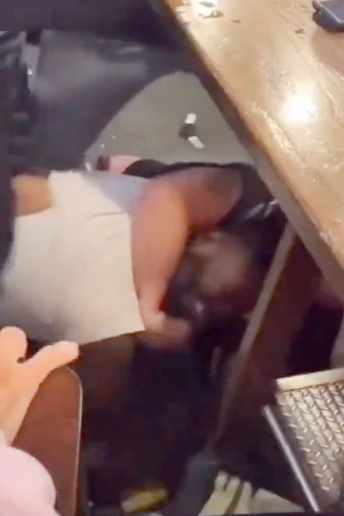 Black patron held in headlock by biker gang.