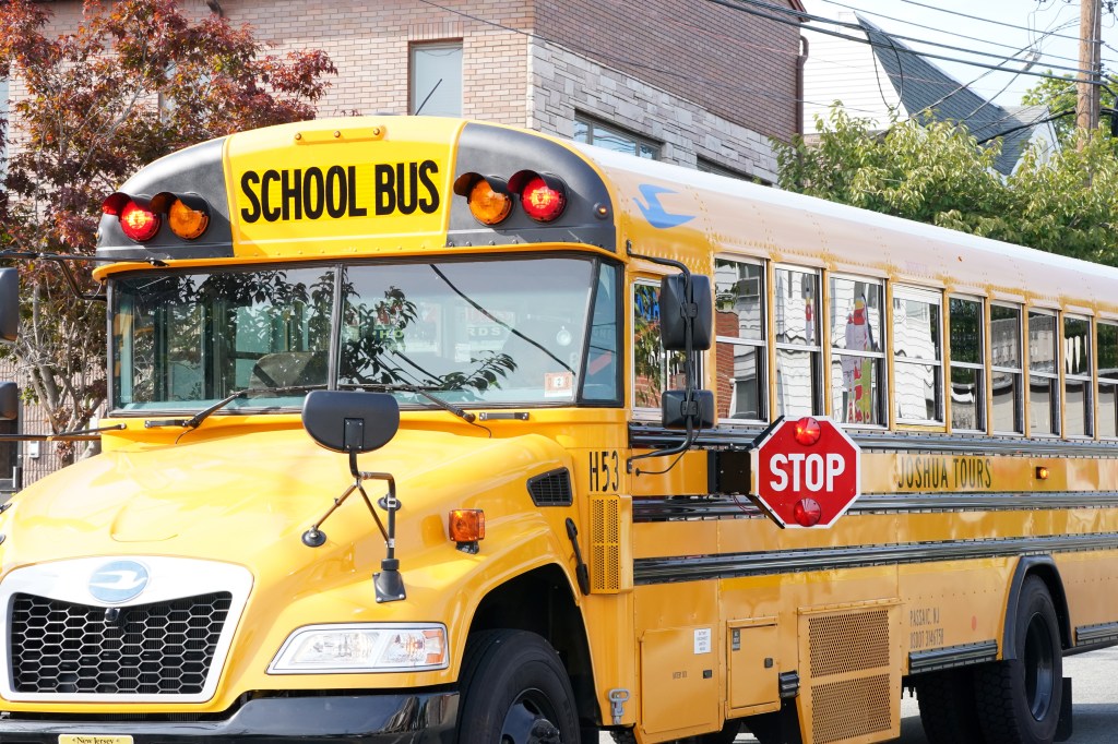 A yellow school bus with its stop sign extended, photographed in Clifton, NJ on September 16, 2024.
