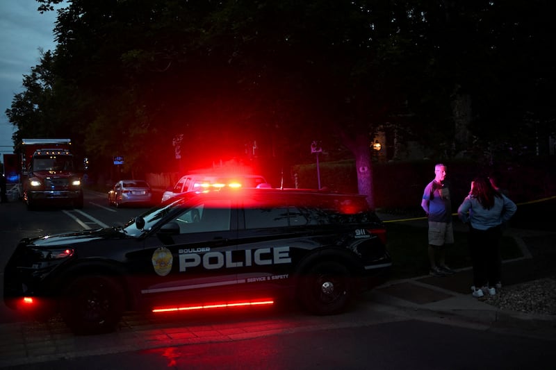 A man is interviewed by members of the media beside a taped police barrier, after an attack that injured multiple people, in Boulder, Colorado.