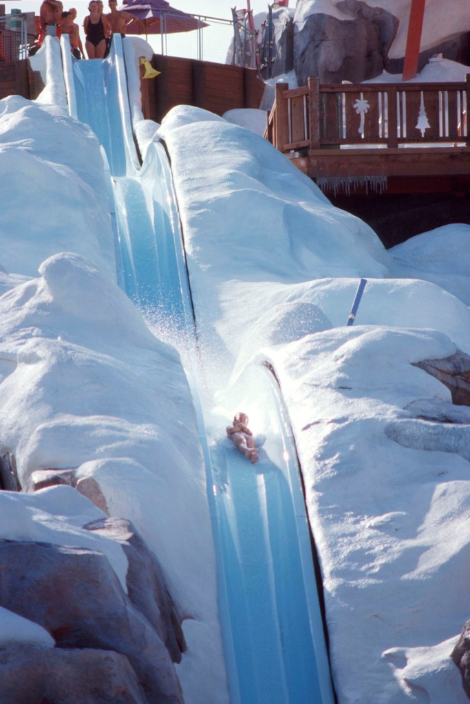 Swimmers speed down the Summit Plummet slide at 55 mph at Blizzard Beach water park, styled like a snowy ski resort in sunny Florida.