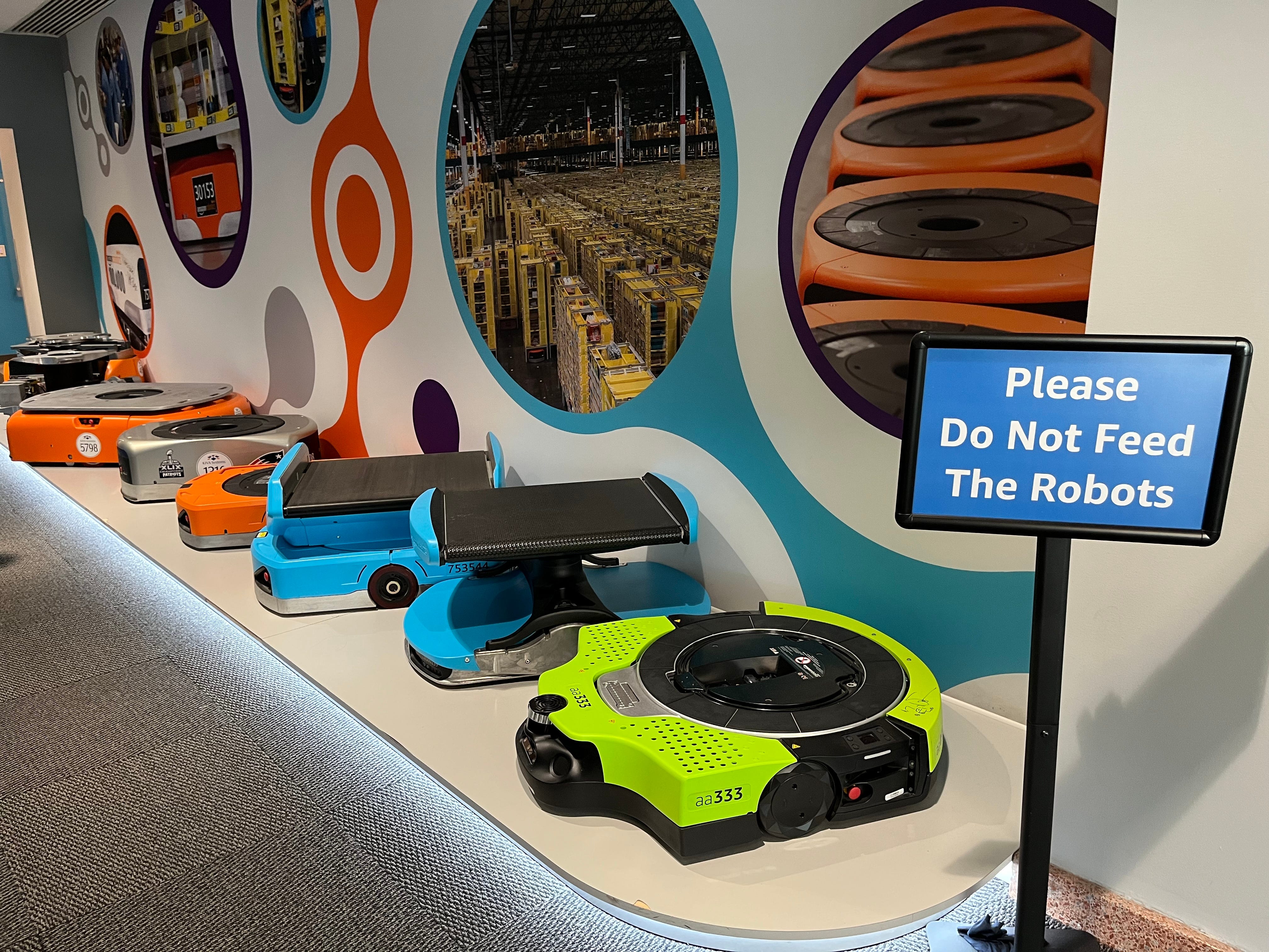A sign in front of Amazon's robots says Please do not feed the robots