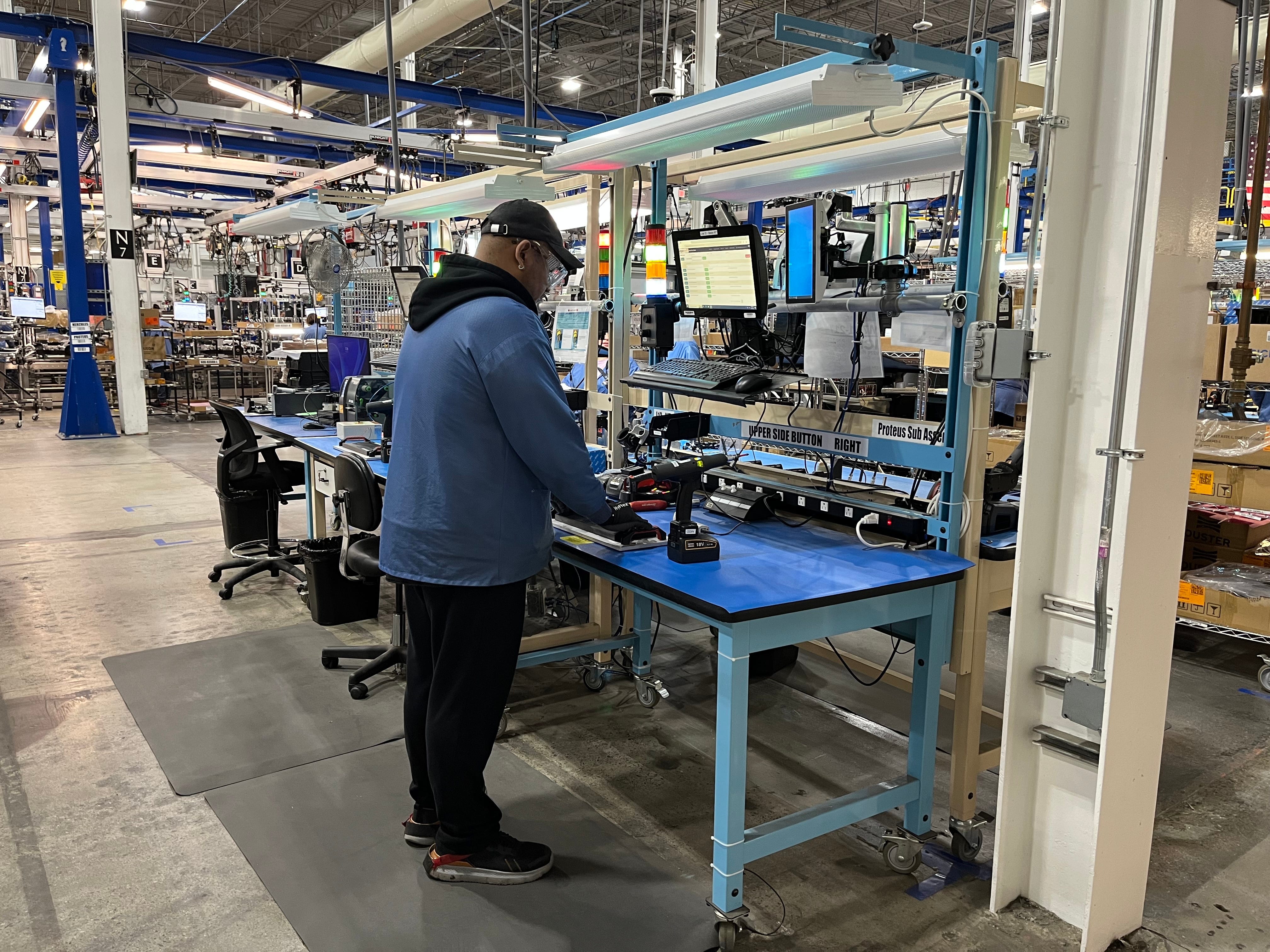 A worker inside Amazon Robotics facility in North Reading assembles sub parts