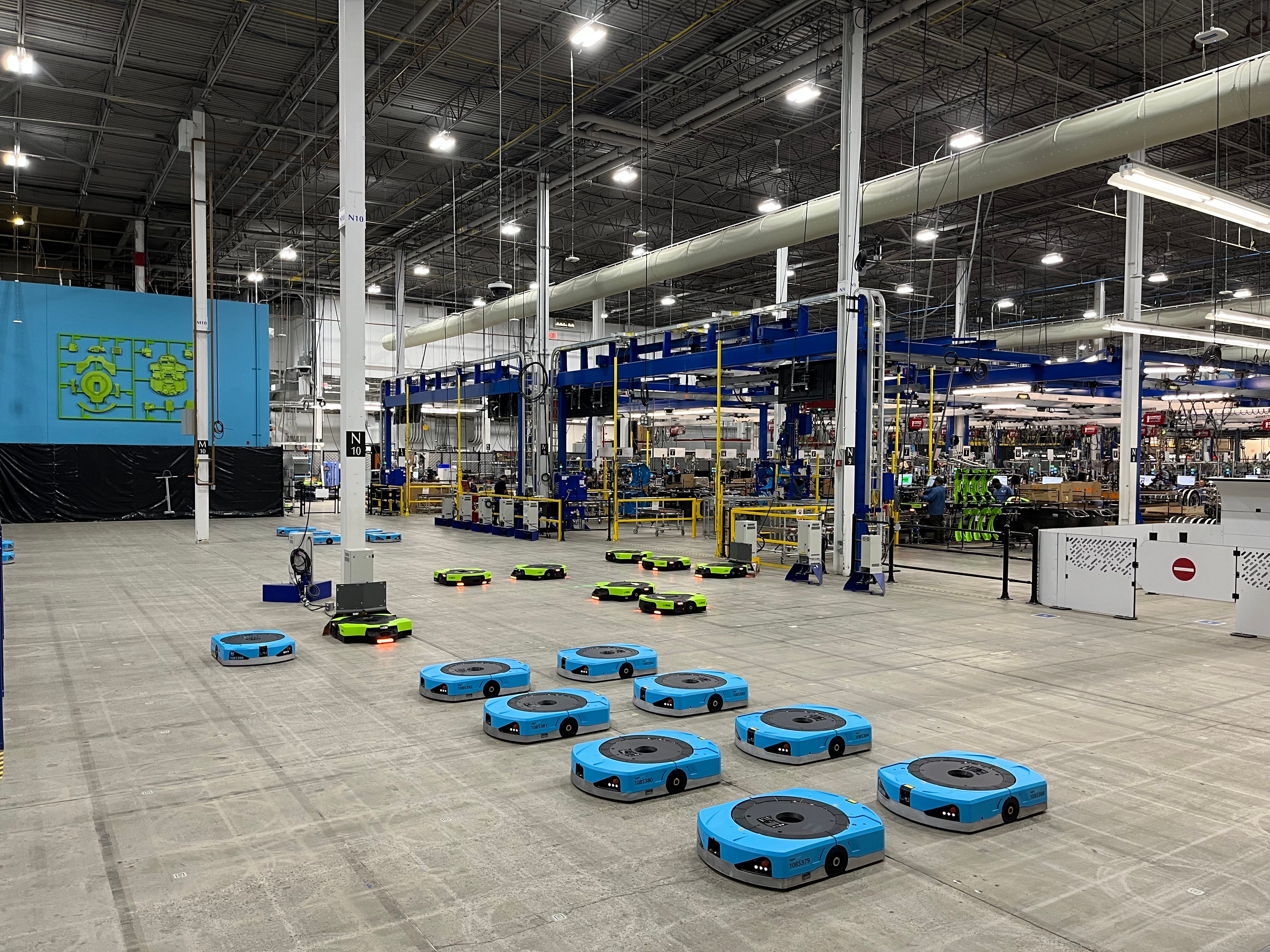 Blue and green robots on the floor in Amazon's manufacturing facility
