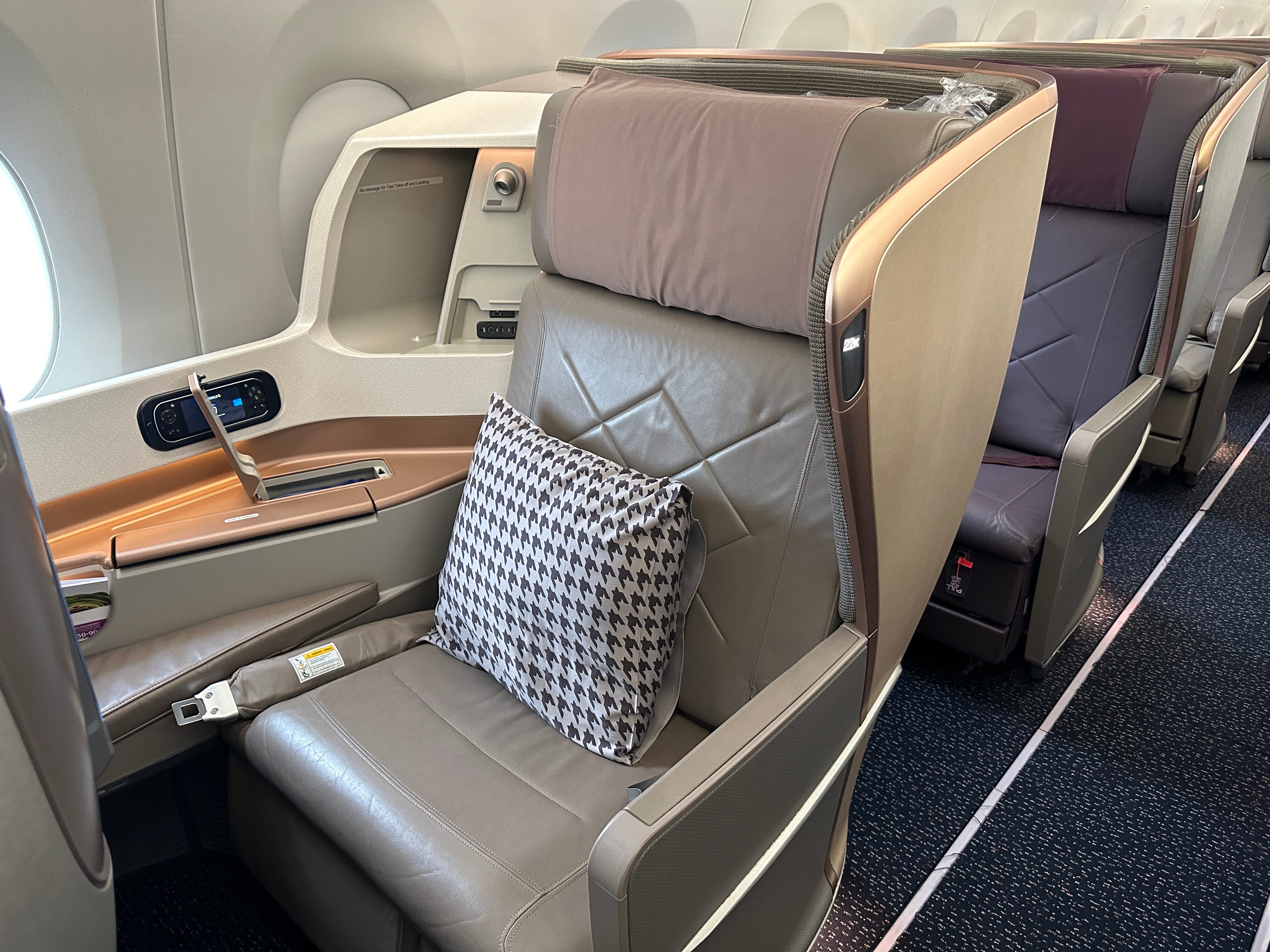 Seat on Singapore airlines flight with pillow, controls on the side