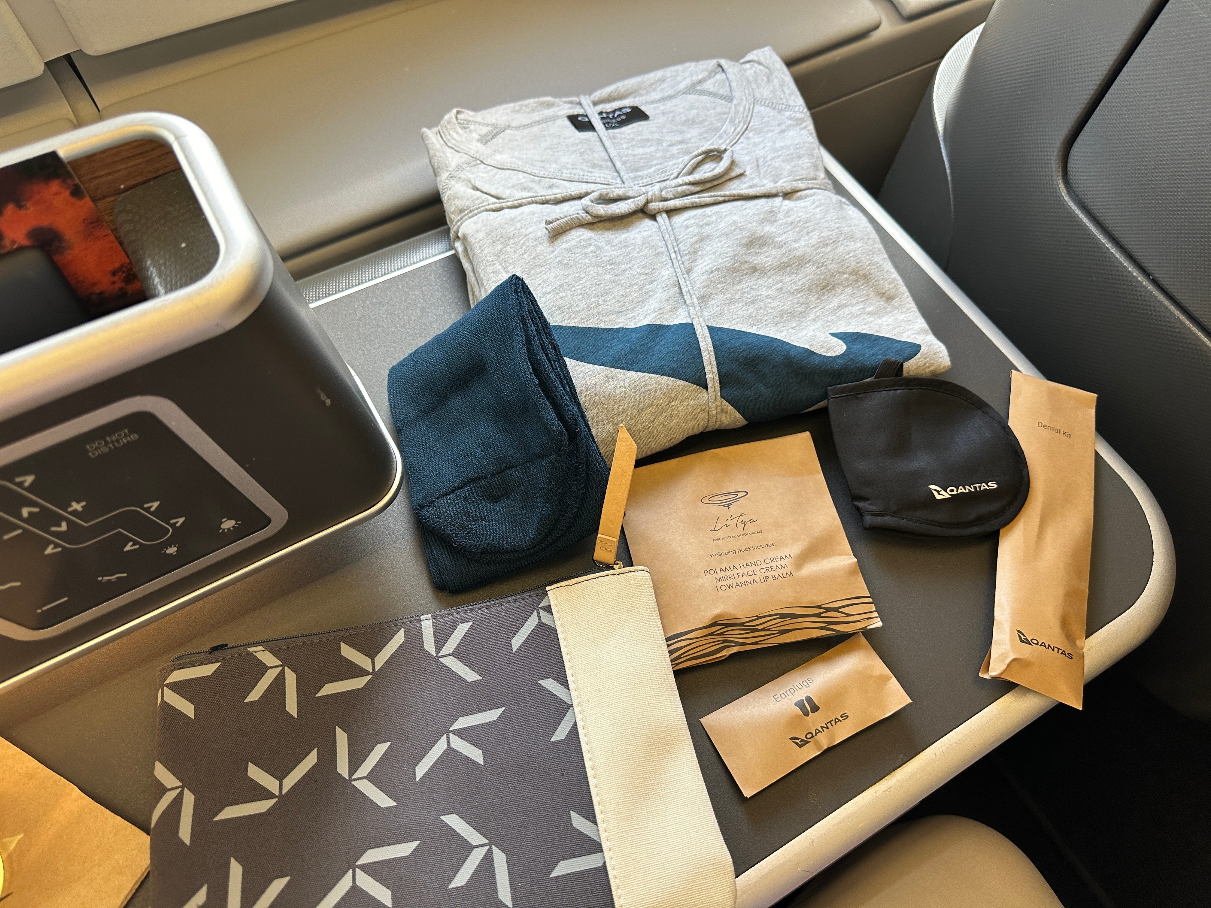 Qantas airline amenity kit with items like socks, eye mask, pajamas