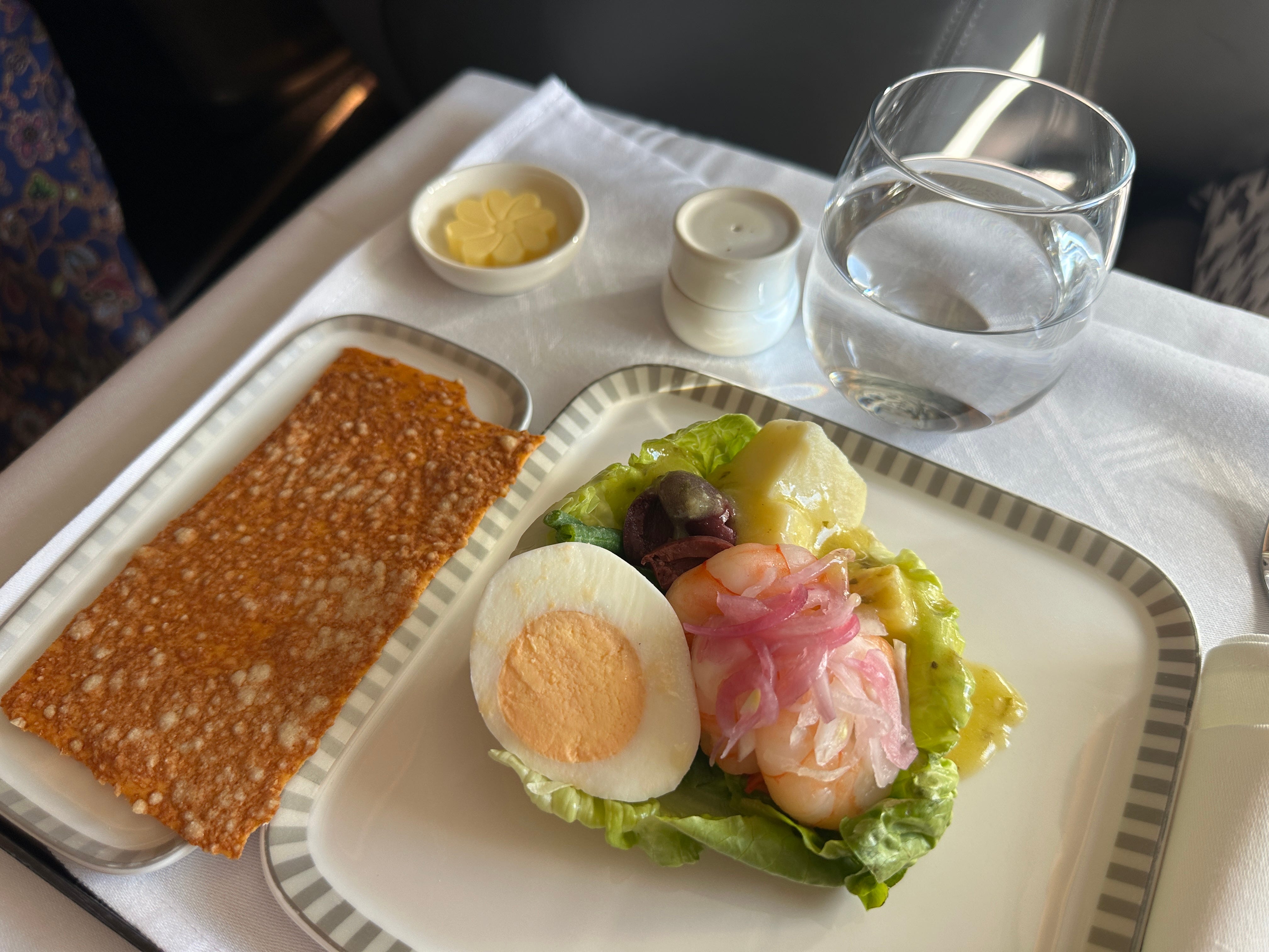 Egg, shrimp, lettuce, and crisp on airplane tray table