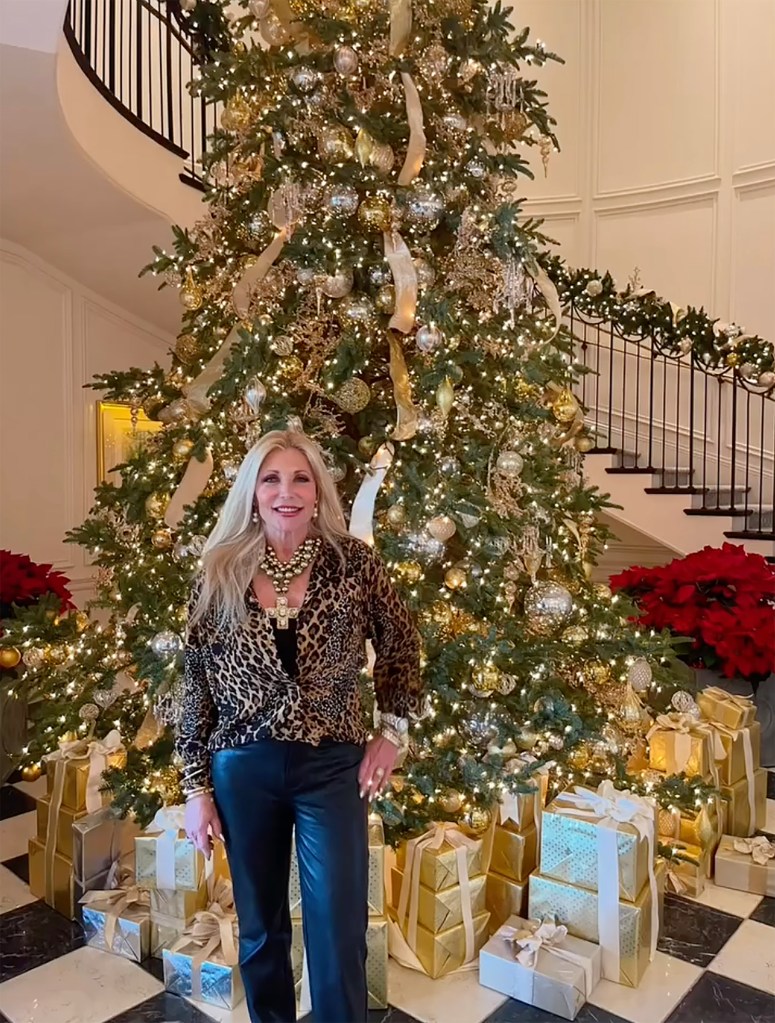 Pamela Bach standing in front of a Christmas tree.