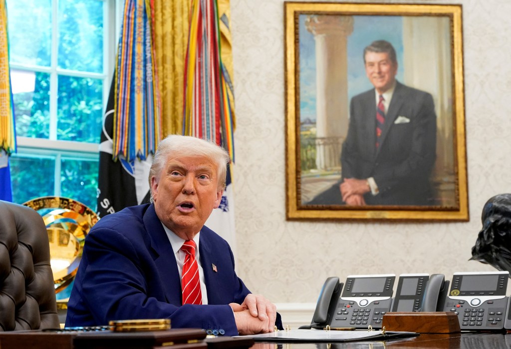 President Donald Trump speaks next to a portrait of former U.S. President Ronald Reagan during a press conference with Elon Musk (not pictured) in the Oval Office of the White House, in Washington, D.C., U.S., May 30, 2025.