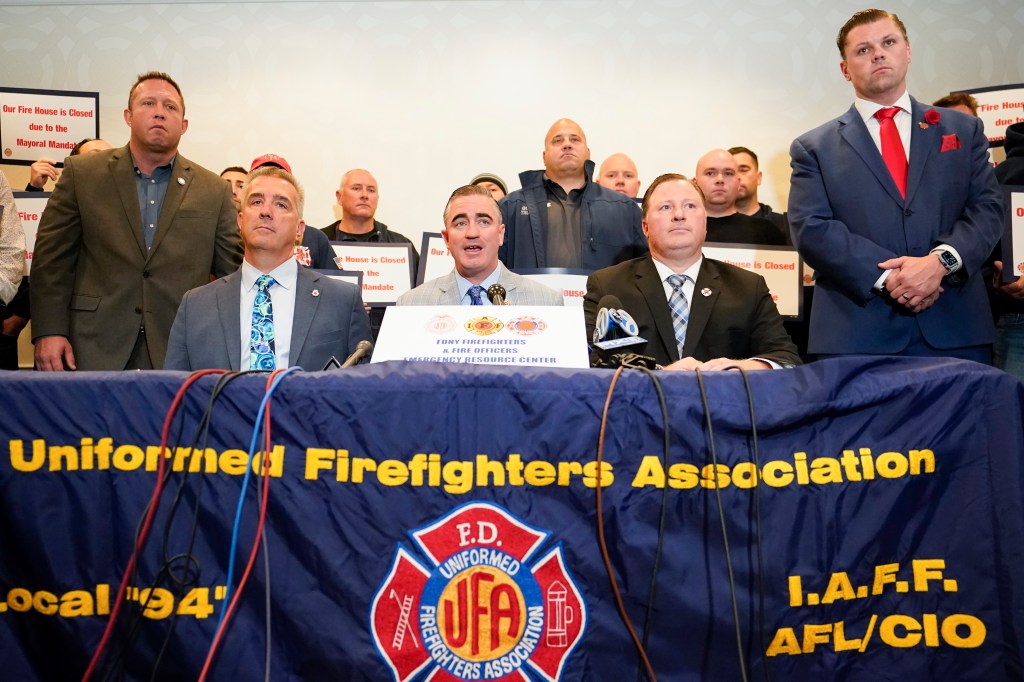 Three firefighters' union presidents at a press conference protesting a vaccine mandate.