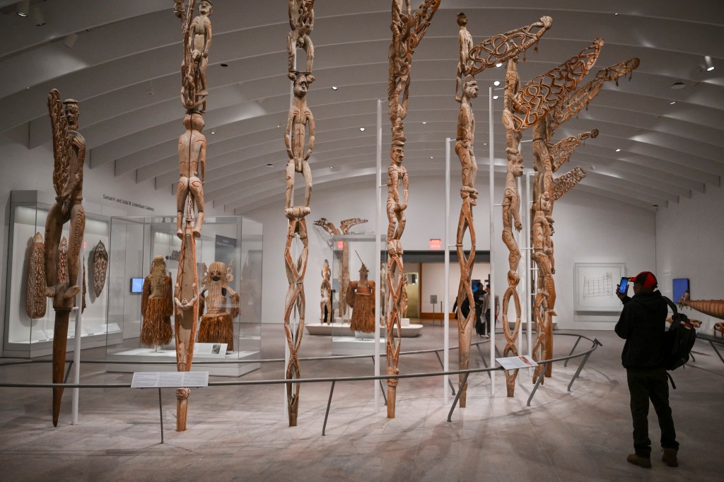 Museum exhibit of tall, carved wooden sculptures.