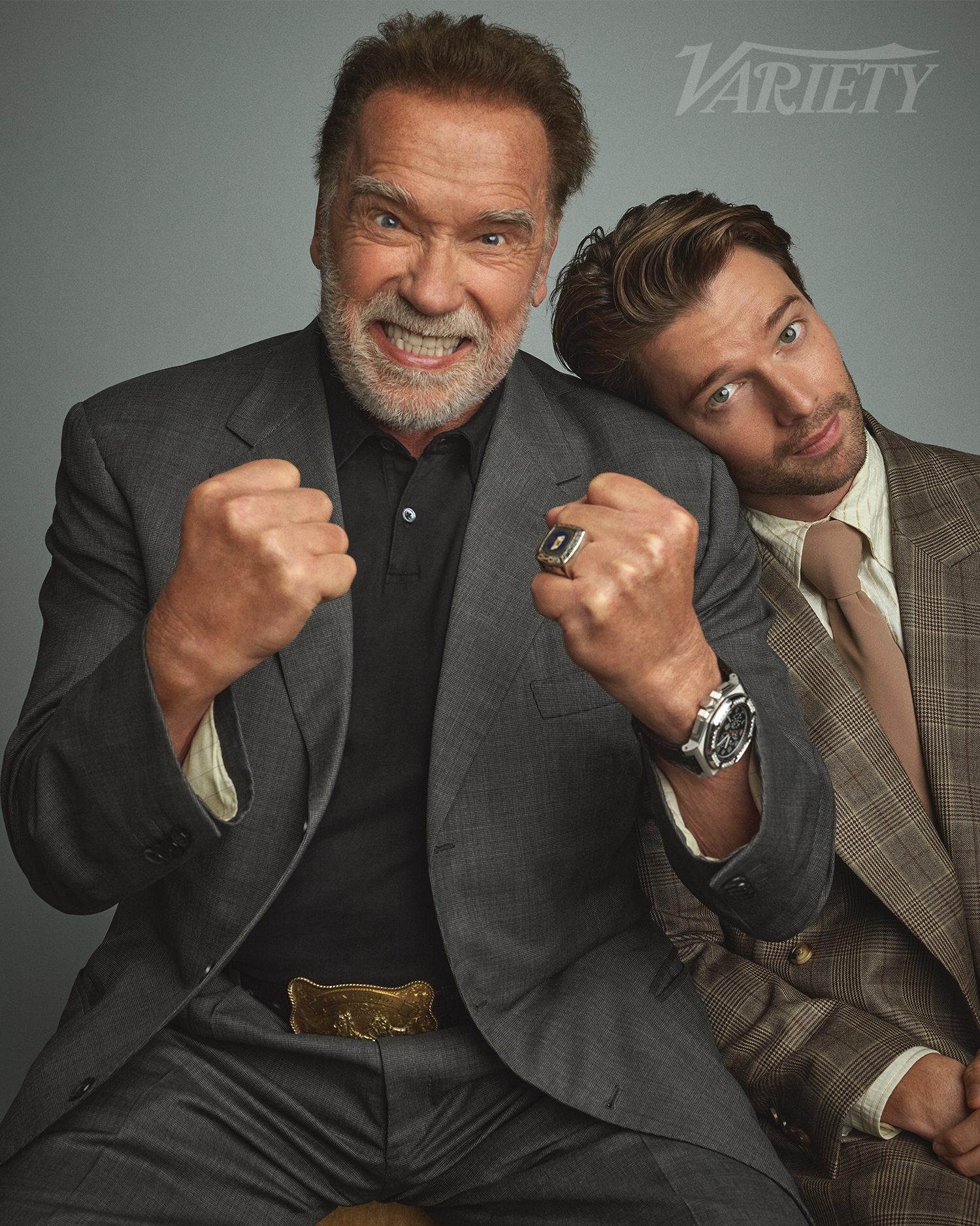 Arnold Schwarzenegger displays his fists while posing with Patrick Schwarzenegger. 