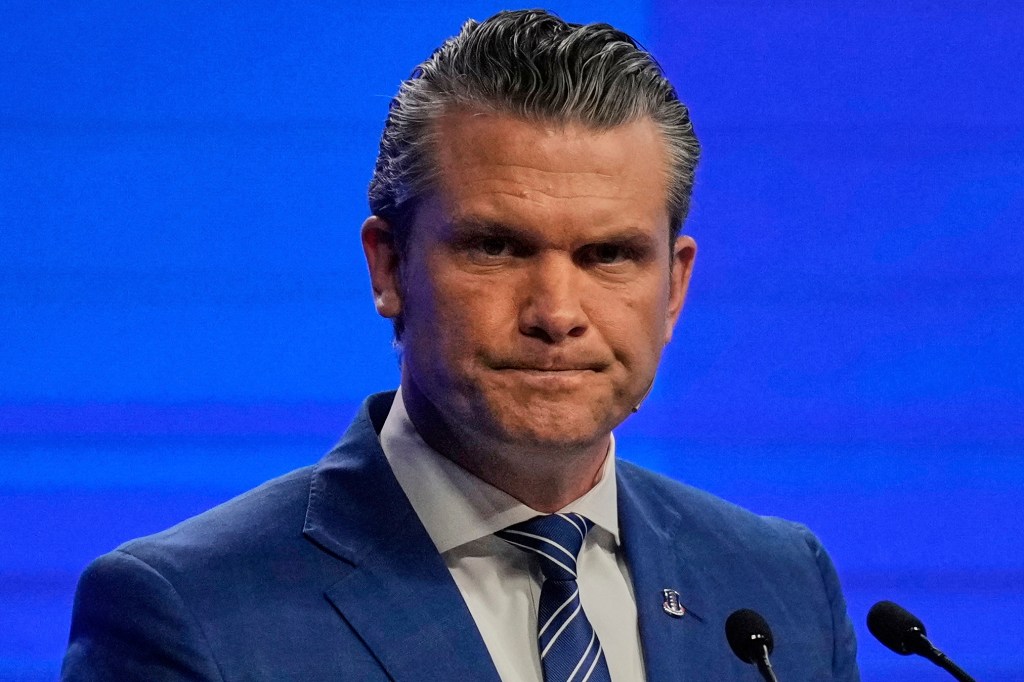 Pete Hegseth speaking at a podium.