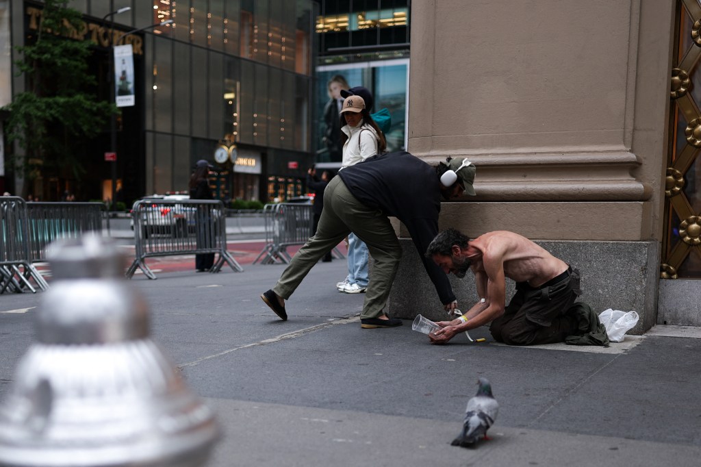 A homeless man begs for money on the street outside Trump Tower on Fifth Avenue in NYC on May 21, 2025.