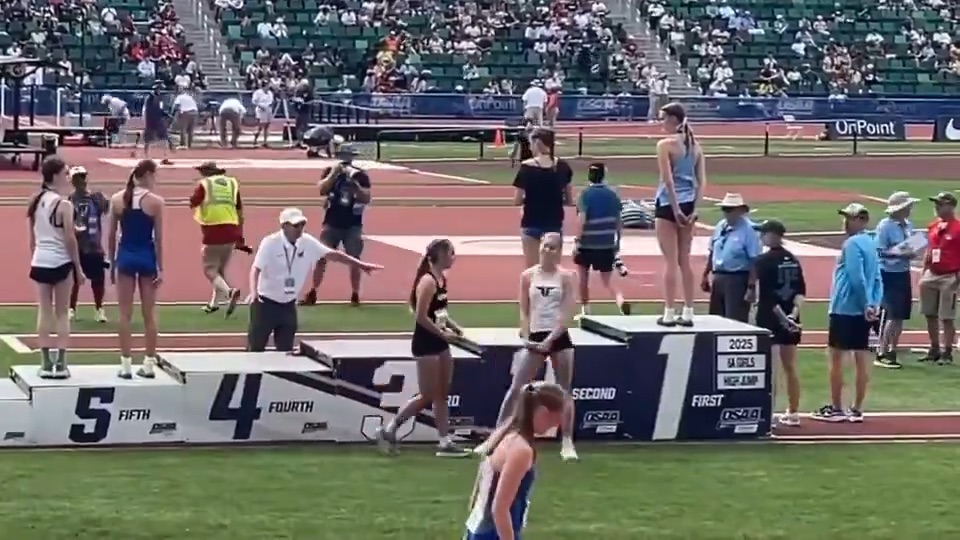 A meet officials tells Eckard and Anderson to move away from the platform during the pictures.