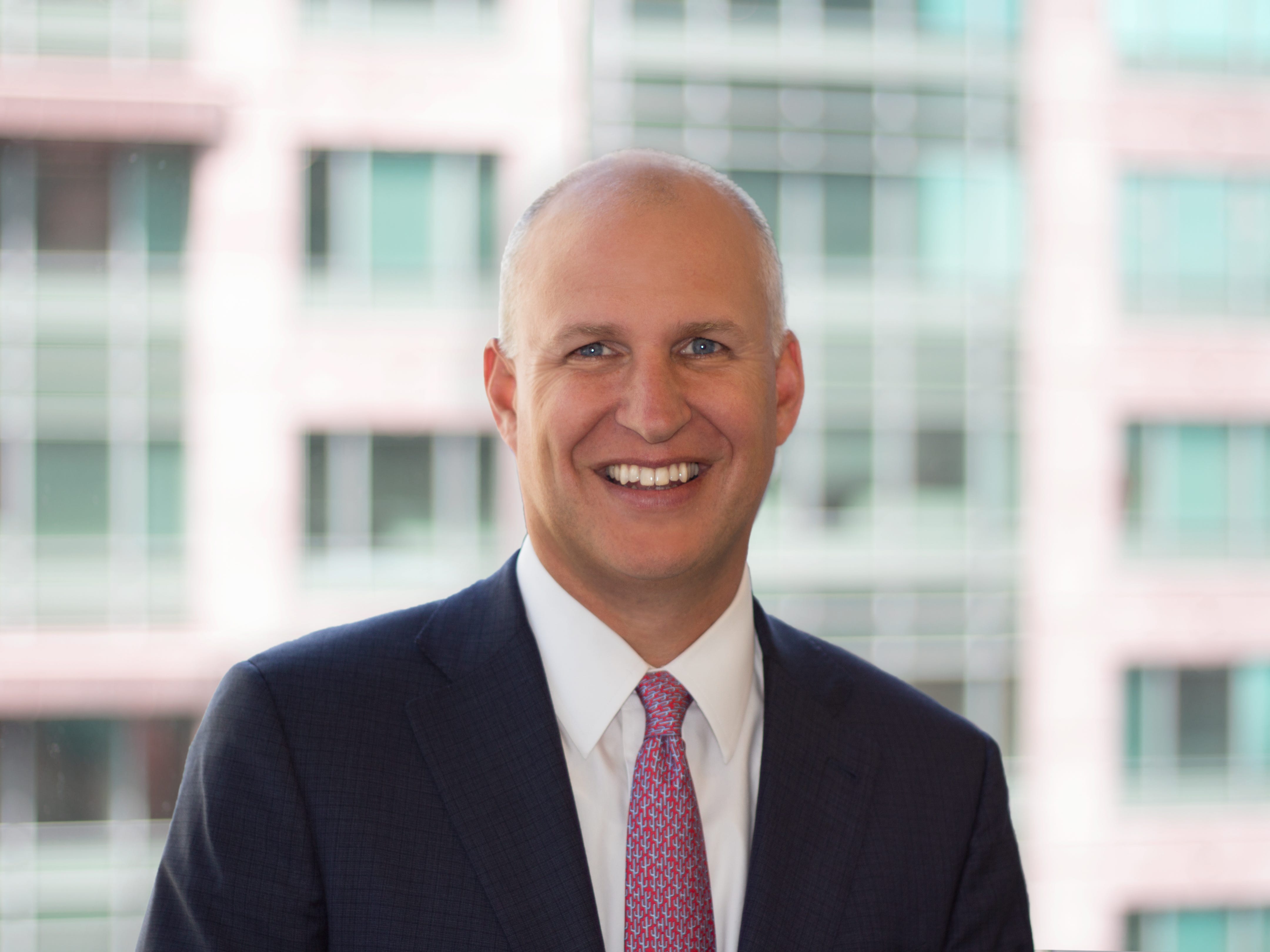 Jeff Akers, Adams Street standing in a suit.
