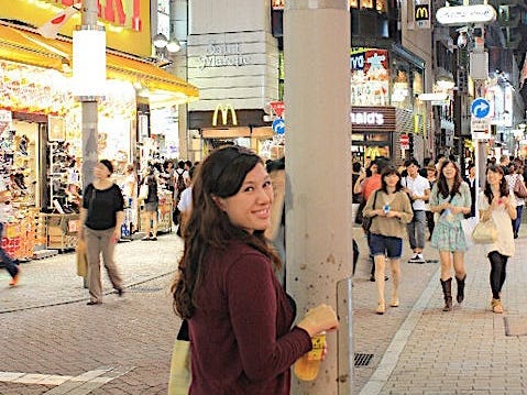 The author on a city street in Tokyo at night among other people.