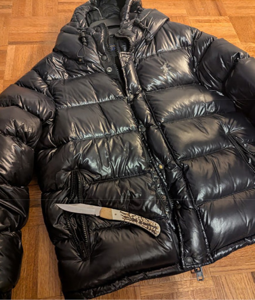 Black puffer jacket with a knife which was found in the pocket.